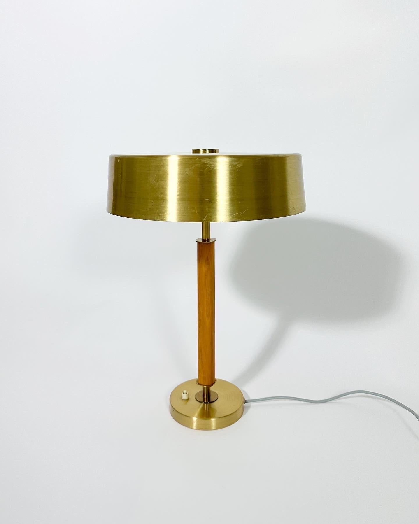 Lampe de table élégante, aux lignes épurées, fabriquée par la société suédoise d'éclairage Boréns dans les années 1960.

Modèle n° B8449 avec un abat-jour en laiton brossé et une tige en bois contrastée. Magnifique bouton en laiton sur le dessus de