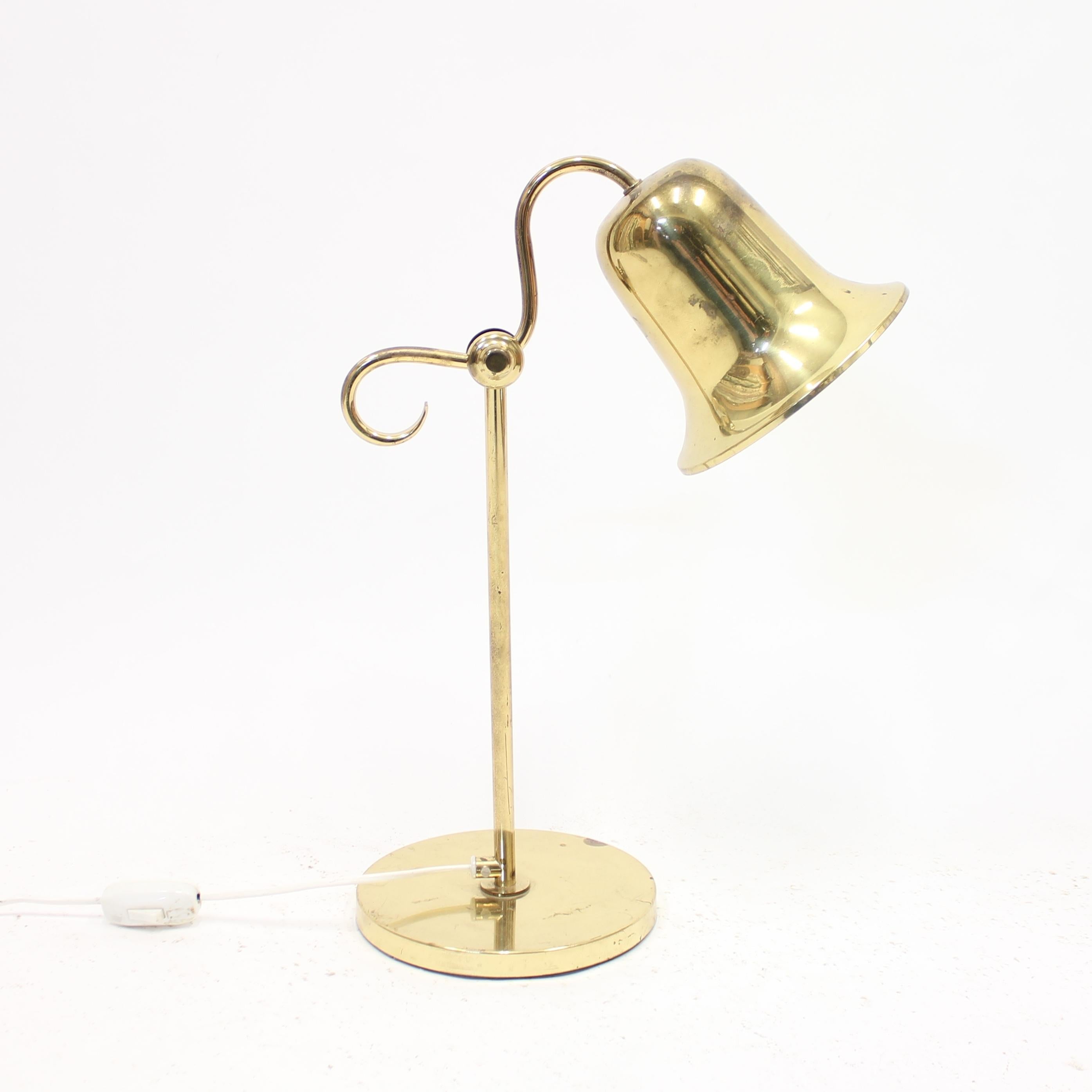 Swedish brass table lamp from the 1970s by Tyringe Konsthantverk with bell shaped shade, mounted on a stem with a round base.The underside marked with sticker from manufacturer and serial number. Overall good vintage condition with normal light