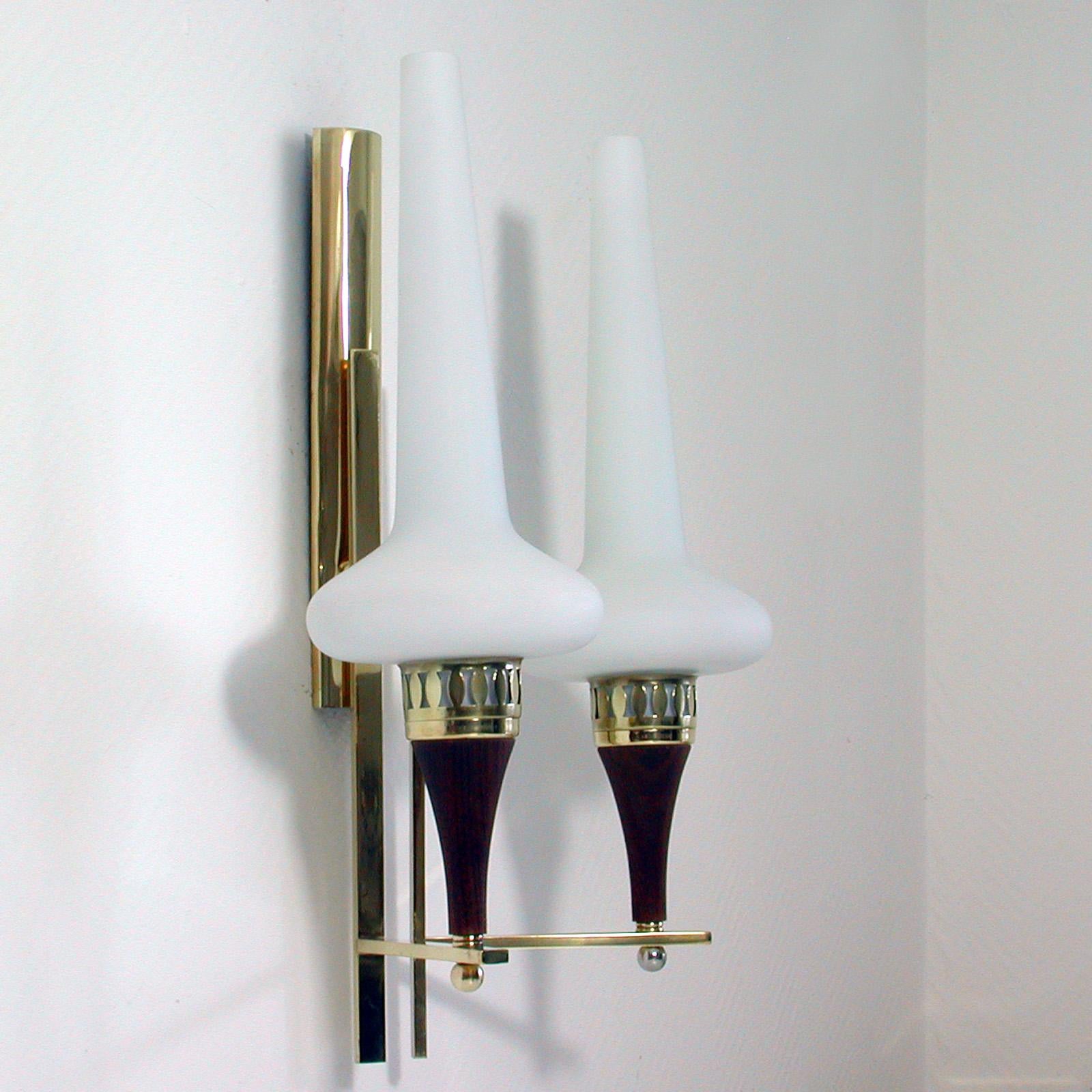 This awesome, very large wall light was produced in Sweden in the 1950s. It was designed by Hans Bergström and manufactured by ASEA. The light is made of teak and brass and has got two opaline glass lamp shades.

The light requires two E14 bulbs.