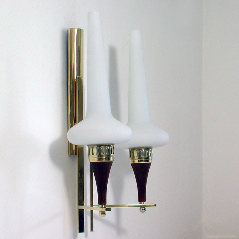 This awesome, very large wall light was produced in Sweden in the 1950s. It was designed by Hans Bergström and manufactured by ASEA. The light is made of teak and brass and has got two opaline glass lamp shades.

The light requires two E14 bulbs.