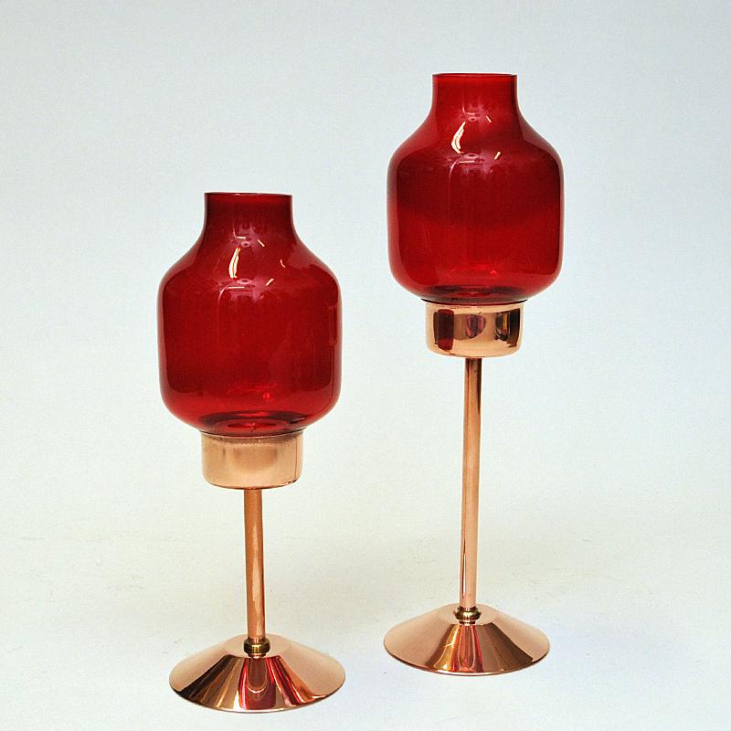 Lovely pair of copper and red coloured glass candle holders by Gnosjö Konstmide 1960s - Sweden. 
Tulip shaped glass shades with pole and base of polished copper. Gives a nice shine when the candleholders are lit. Removable shades - so can also be