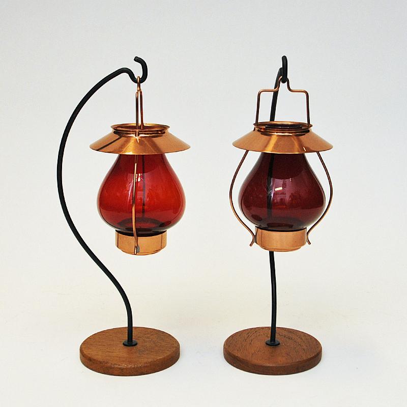 Lovely couple of copper and red colored glass hanging candle holders by Gunnar Ander for Ystad Metall 1960s - Sweden. 
Tulip shaped glass shades and holder of polished copper. Gives a nice shine when the candles are lit. Removable shades and