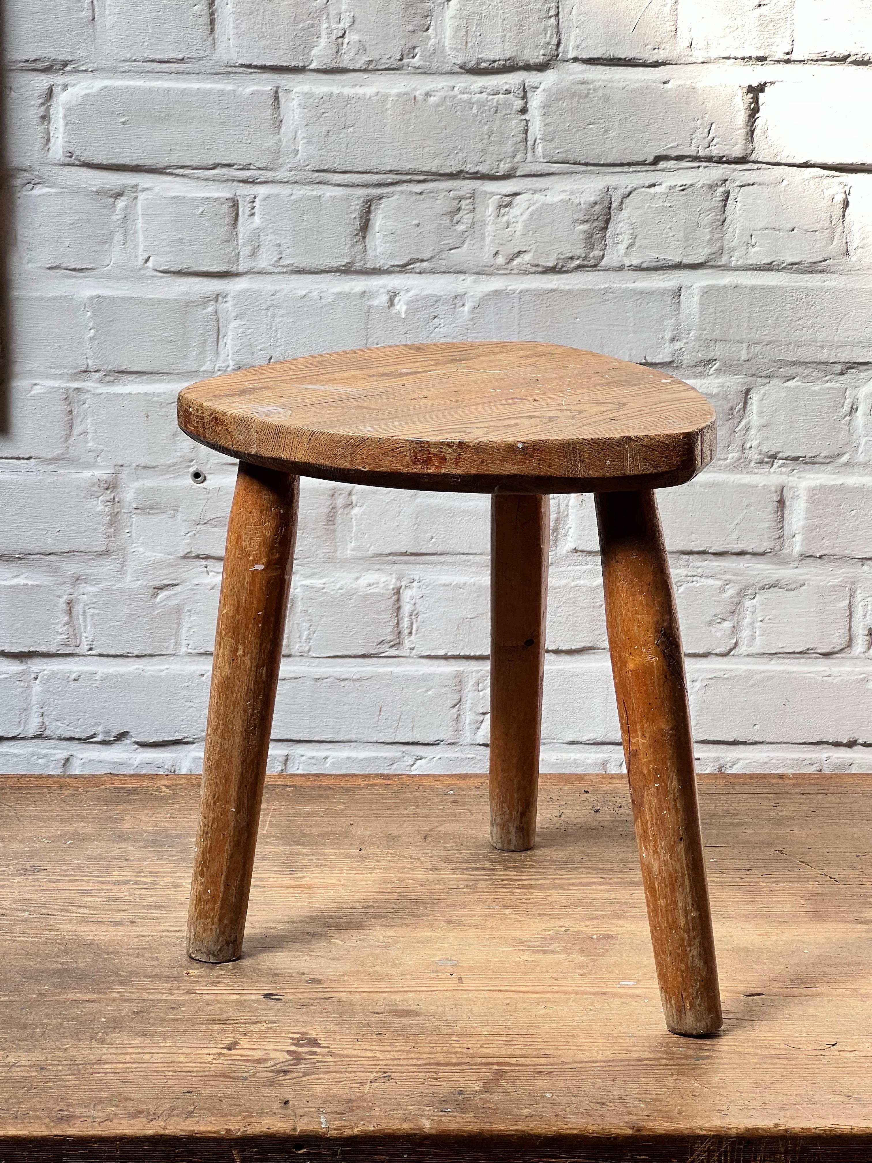 Very unique pine handmade massive slay of tree. It is a free form shape. The top is patinated and shows various shades of brown/brownish colors and honey tones. Elegant and brutalist describe that stool properly. Very strong stool. Lovely used as a