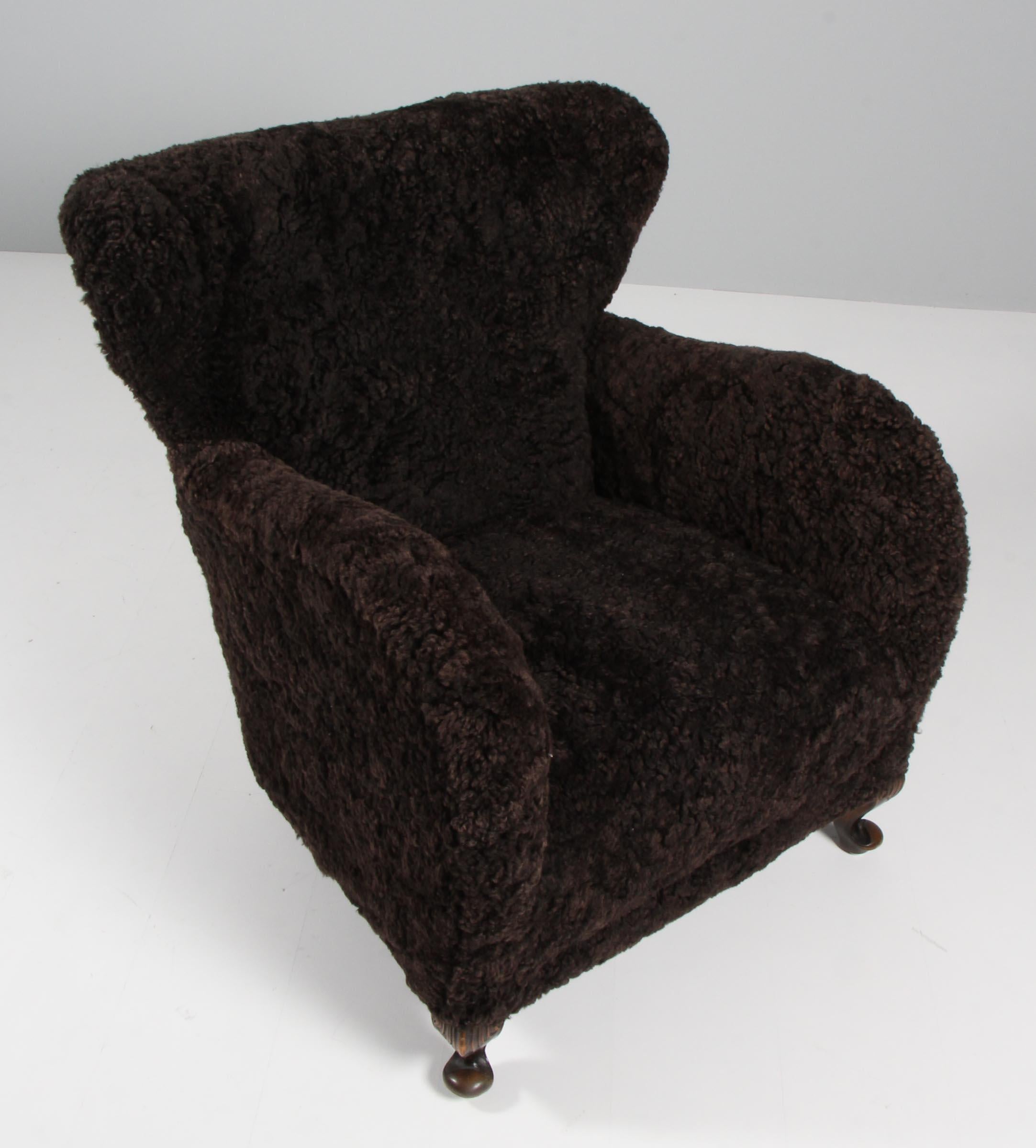 Swedish cabinetmaker lounge chair new upholstered with lambskin.

Legs of stained beech.

Made in the 1940s.