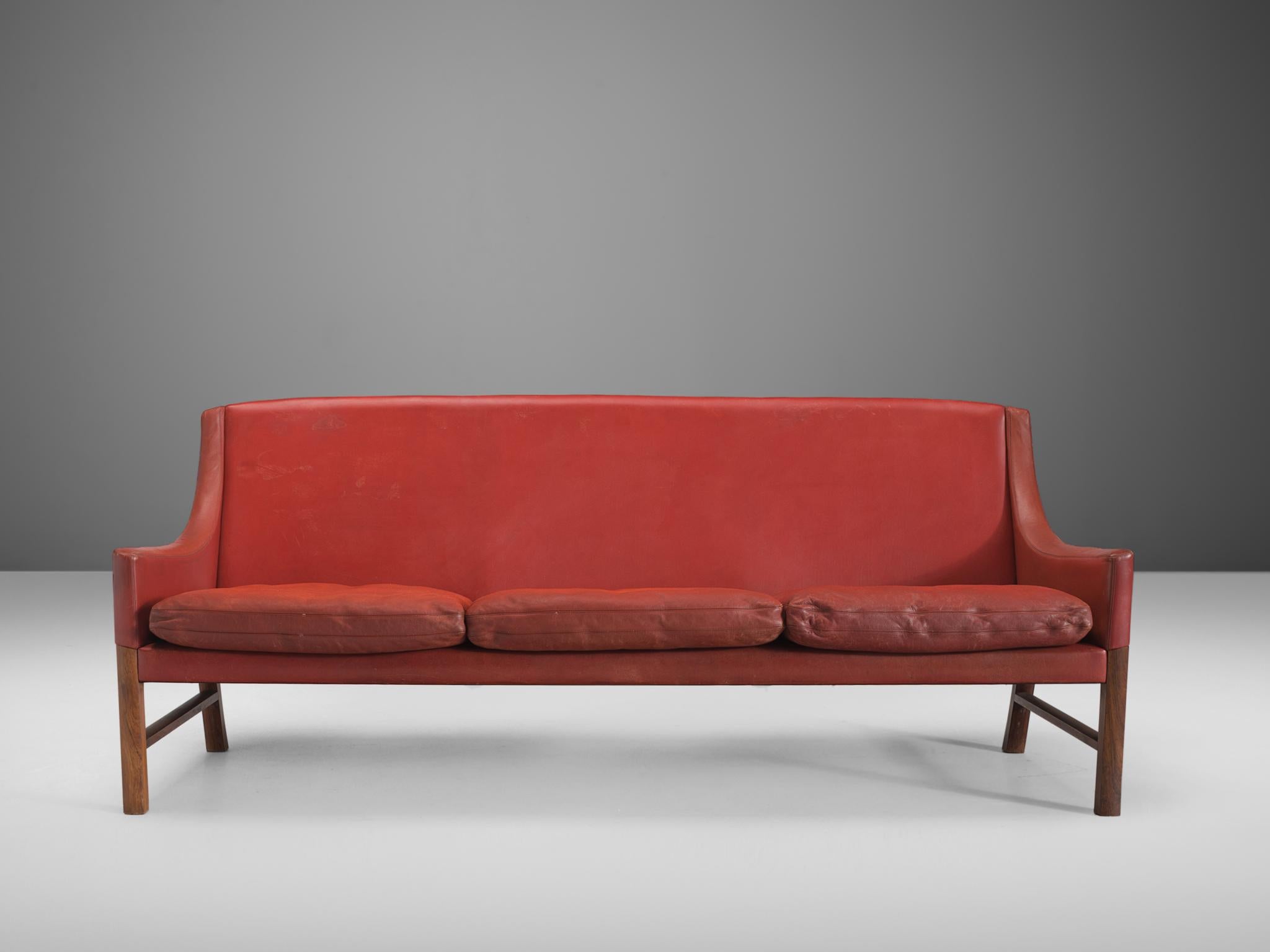 Settee, red leather, cocobolo, Sweden, 1950s.

This elegant settee shows traits of the Swedish designer Alf Svensson and Kai Kristiansen. The sofa has pointy armrests and a wonderful grained cocobolo frame. The cushions are comfortable and well