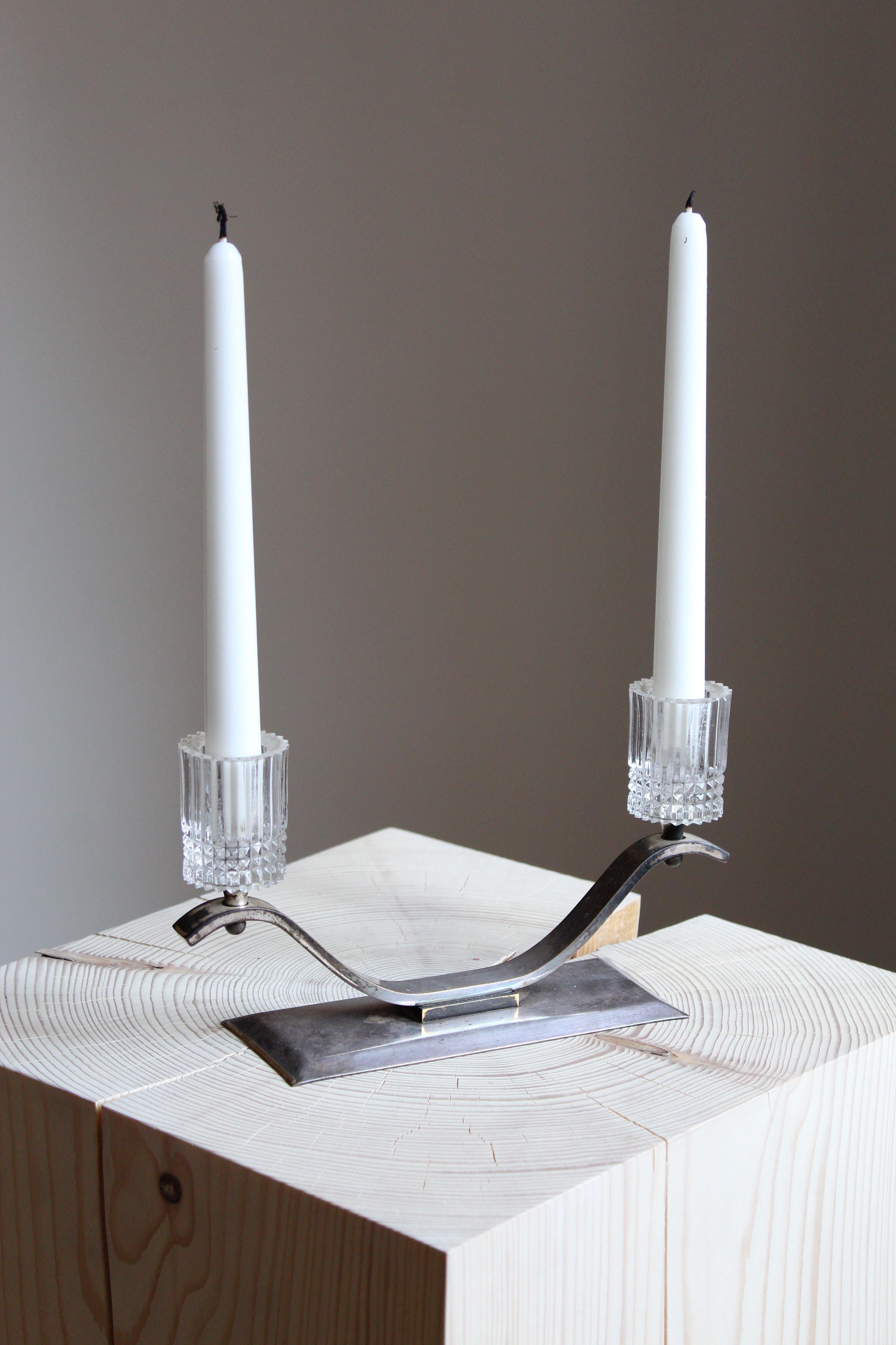 A candle holder. Designed and produced in Sweden, 1940s. In steel and glass.

 