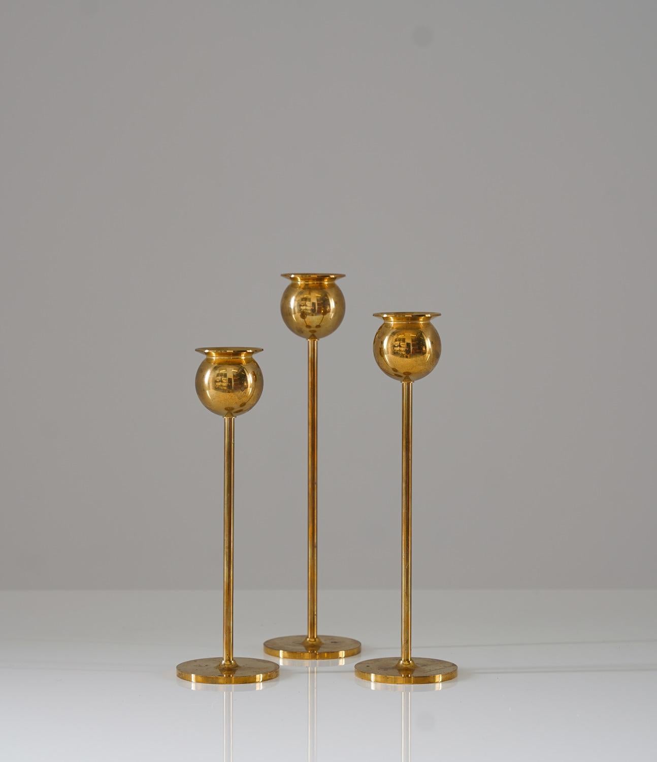 Add a touch of elegance to any space with this set of three stunning candlesticks in brass by Pierre Forsell for Skultuna, Sweden. Measuring 23, 21, and 19cm in height, these candlesticks are the perfect height for any tabletop or mantle. The brass