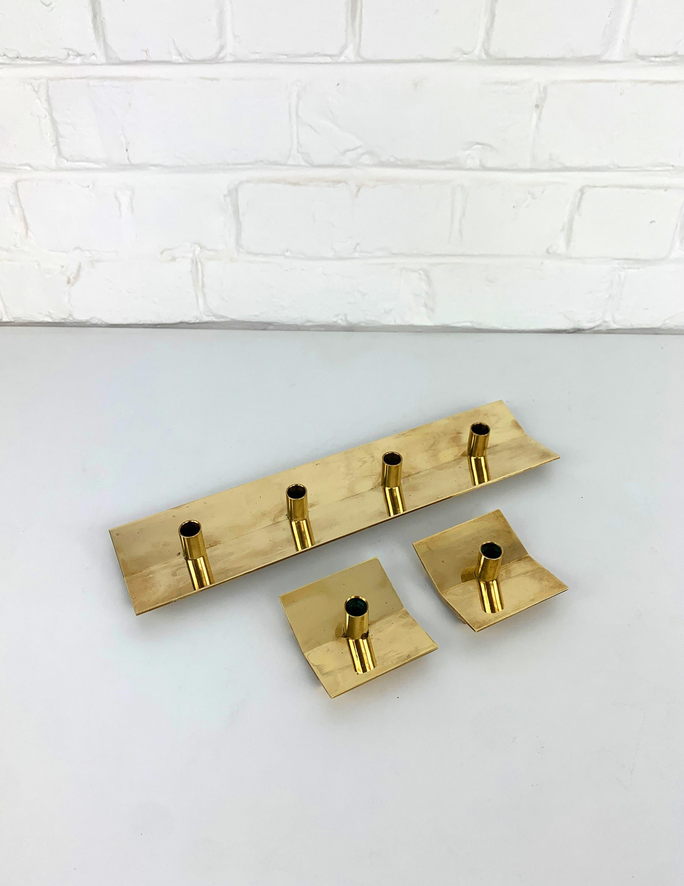 Set of 3 candleholders by Pierre Forssell made of solid brass. 

Combination of one candle-holder model N°69 for 4 candles and two candlesticks model N°70 for 1 candle each.

Designed by Pierre Forssell and manufactured in Sweden by Skultuna. The