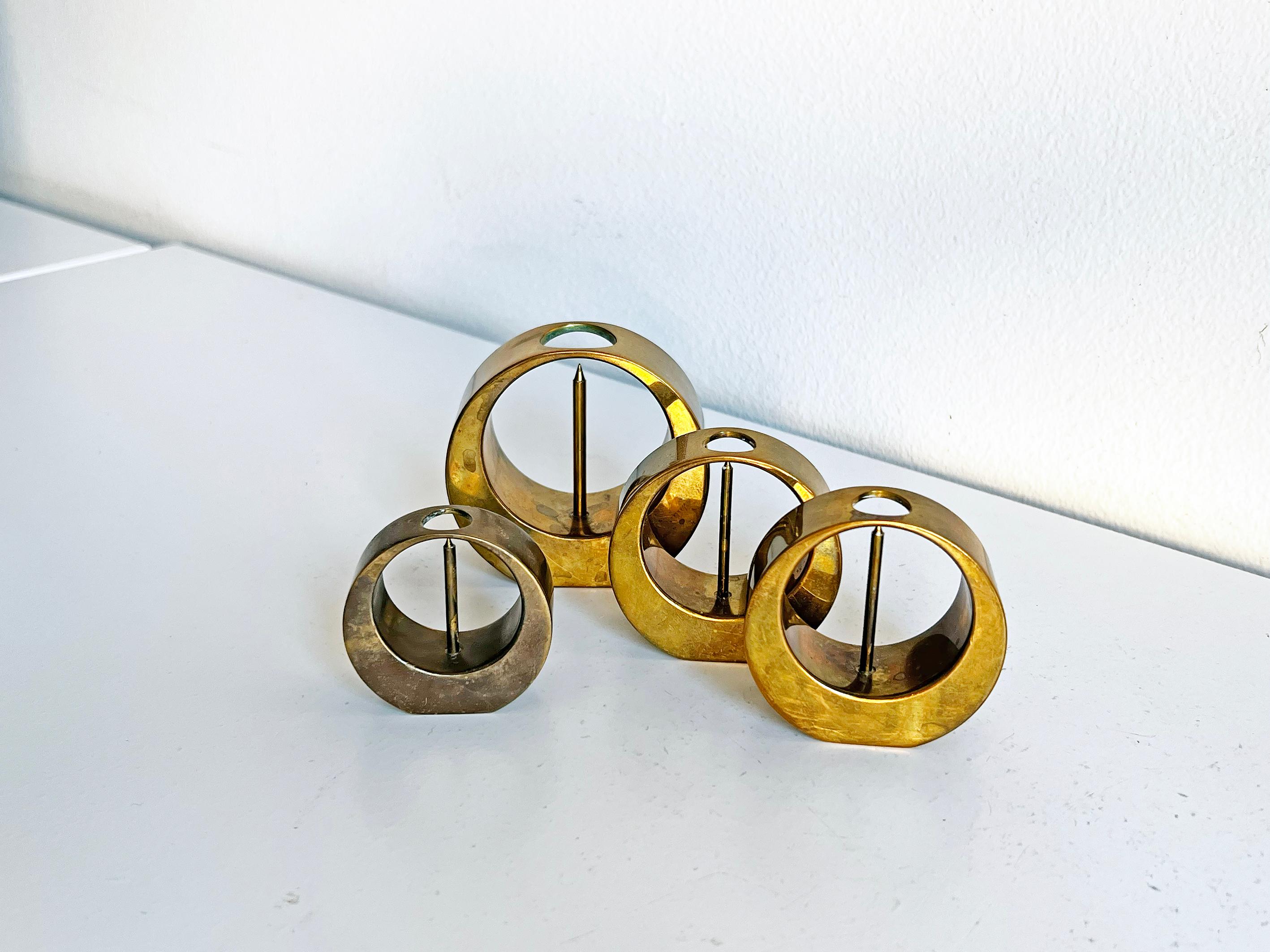Set of 4 candlesticks designed by Arthur Pe. Produced in his own studio Kolbäck in Sweden. Brass with patina. 

3 different measurements: 
Height 4.9 cm, width 5 cm, depth 2.3 cm
Height 5.9 cm, width 5,9 cm, depth 2.6 cm
Height 7.2 cm, width 7,5 cm,