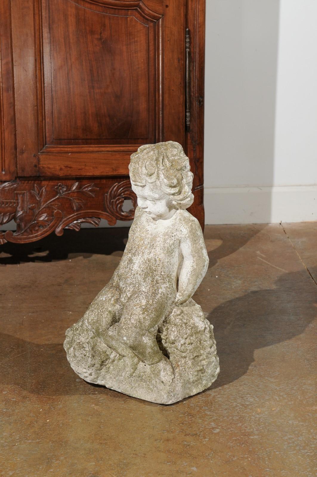 Pierre Sculpture de jardin suédoise en pierre sculptée représentant un putto assis sur une roche, 20ème siècle en vente