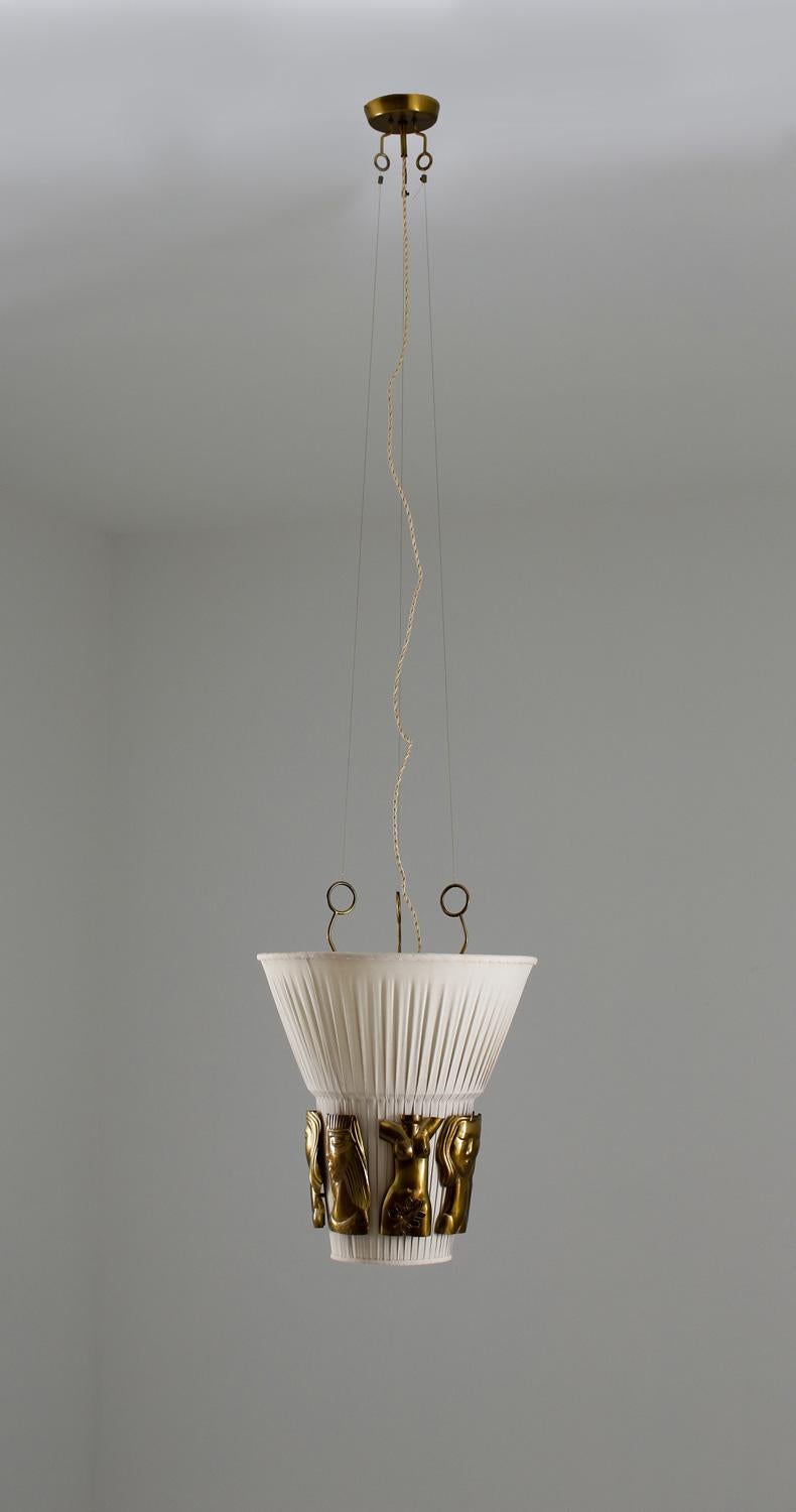 Very rare ceiling lamp with nudes by Hans Bergström for Ateljé Lyktan, Sweden. 
This lamp shows impressive handcrafted details, such as the hand hammered brass ornaments that surrounds the shade. The lamps have two light sources, one uplight and