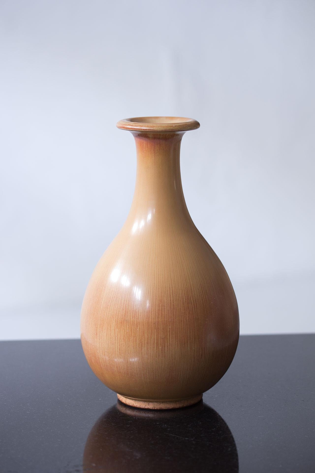 Magnifique vase en céramique conçu par Gunnar Nylund, fabriqué par Rörstrand en Suède dans les années 1940. Réalisé en grès avec une glaçure au poil de lièvre de couleur sable à ocre rouge.

Gunnar Nylund était directeur artistique de la société de