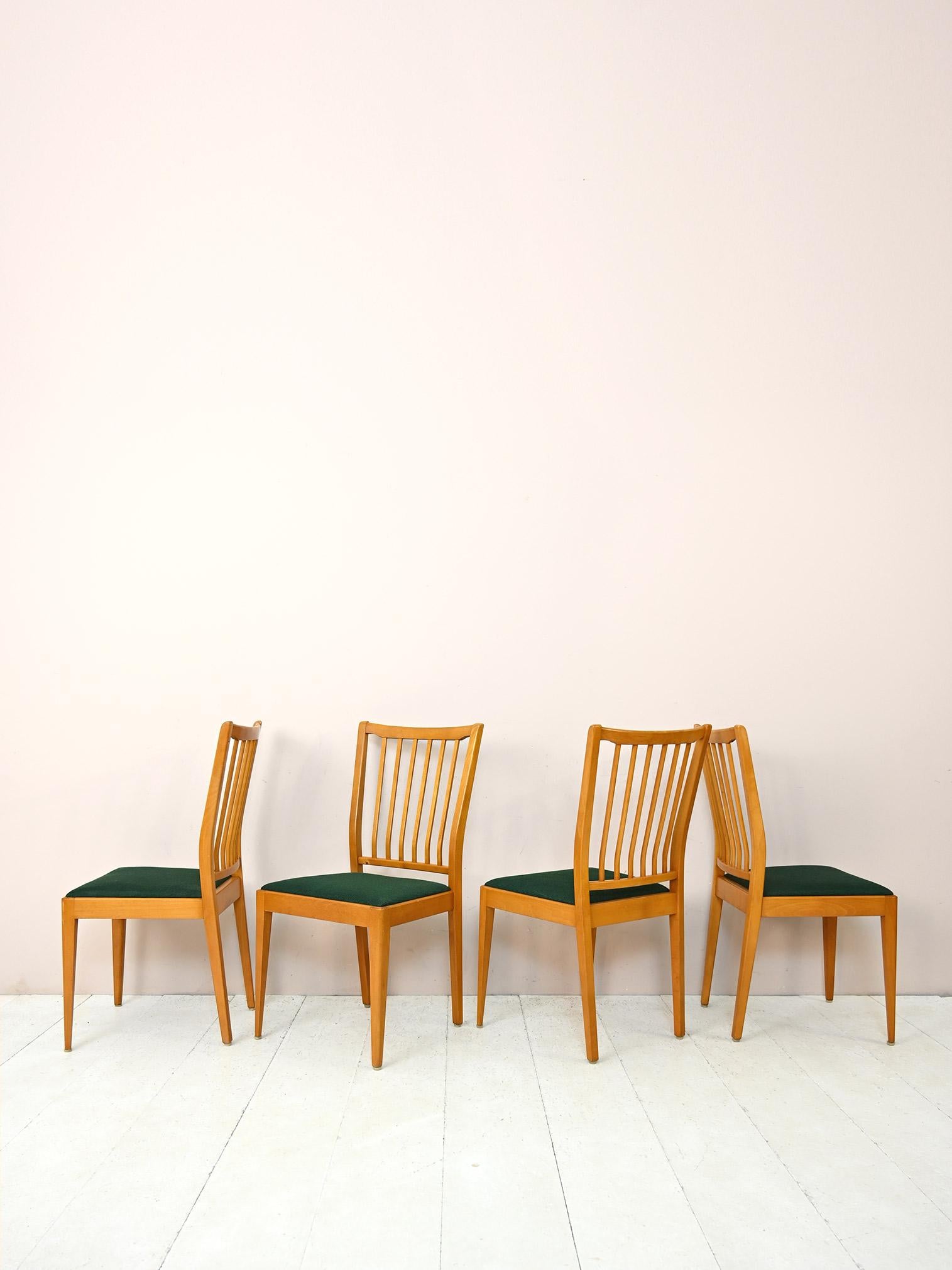 Set of 4 original vintage wooden chairs.
Retro-flavoured chairs consisting of a birch wood frame and an upholstered seat lined with original vintage green fabric.
The backrest is slightly contoured and consists of wooden stems. The legs are tapered