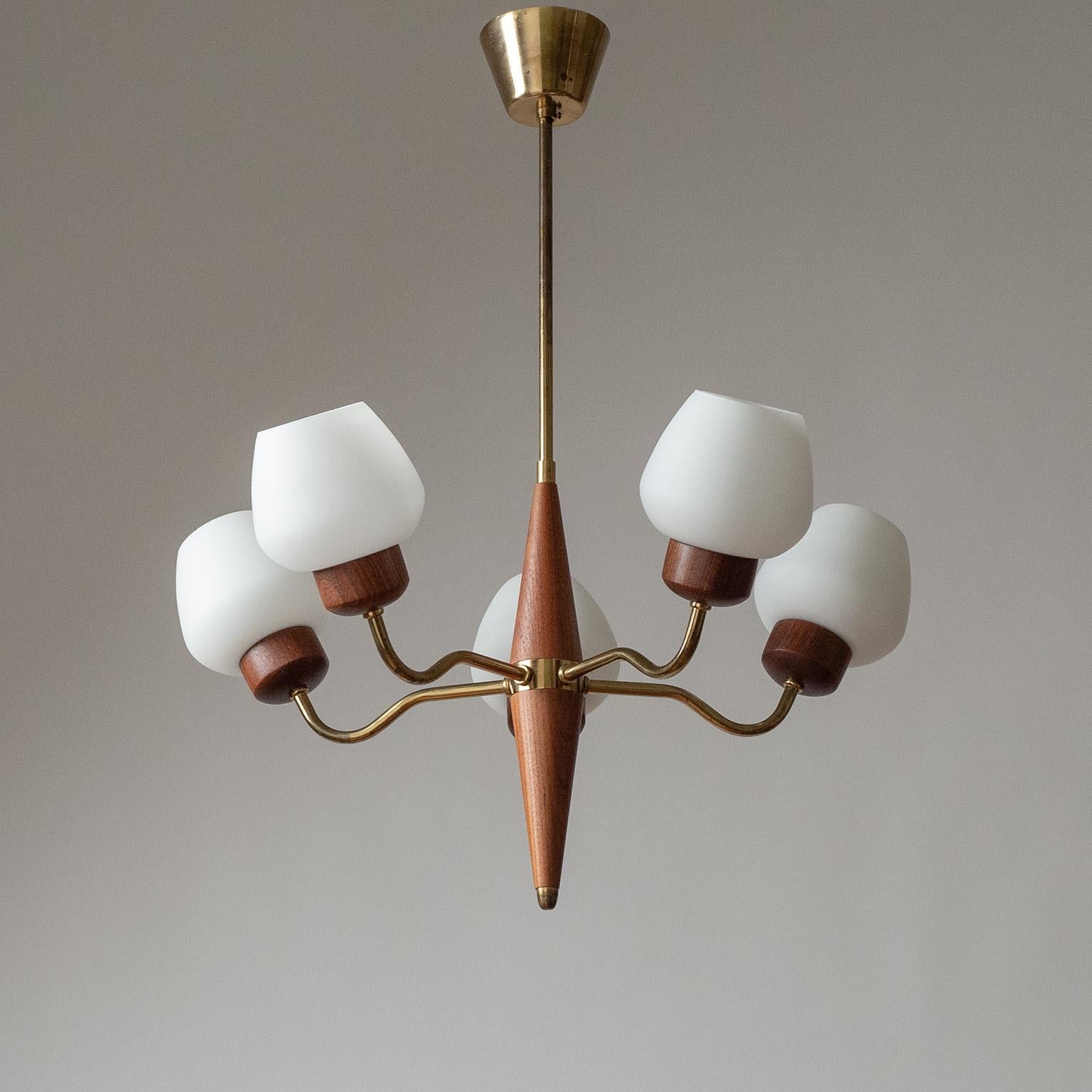 Fine Swedish 5-arm chandelier fro the 1950s. Sleek solid teak centerpiece with five brass arms, each with a solid teak socket cover and satin glass diffuser. Original bakelite E27 sockets with new wiring.
Body height 30cm/12inches.