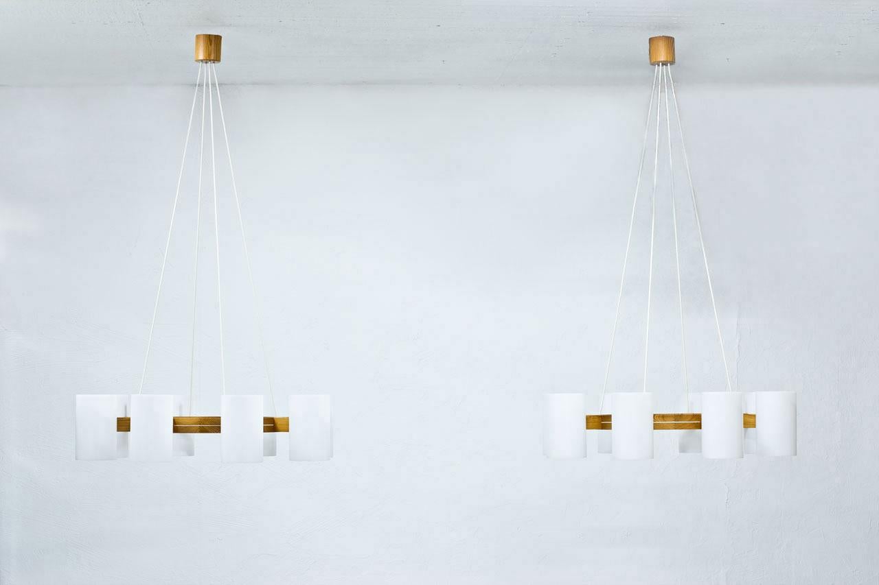 Large and beautiful chandelier designed by Uno & Östen Kristiansson for their own company Luxus. Manufactured at Vittsjö in Sweden during the 1960s. 
Lamps are made from in a solid pine structure with eight large acrylic diffusers.
The height of