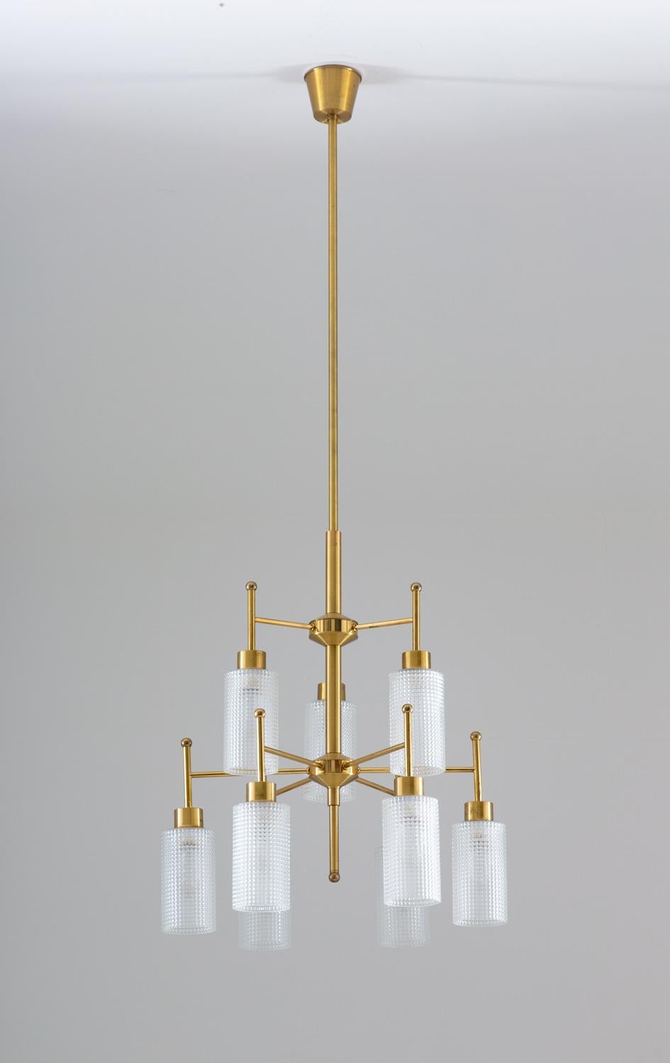 Mid century modern chandeliers by Holger Johansson for Westal, Sweden.
The chandeliers consist of nine round brass poles divided into two levels, each holding a cylinder-shaped glass shade.
The rods can be adjusted to your desired