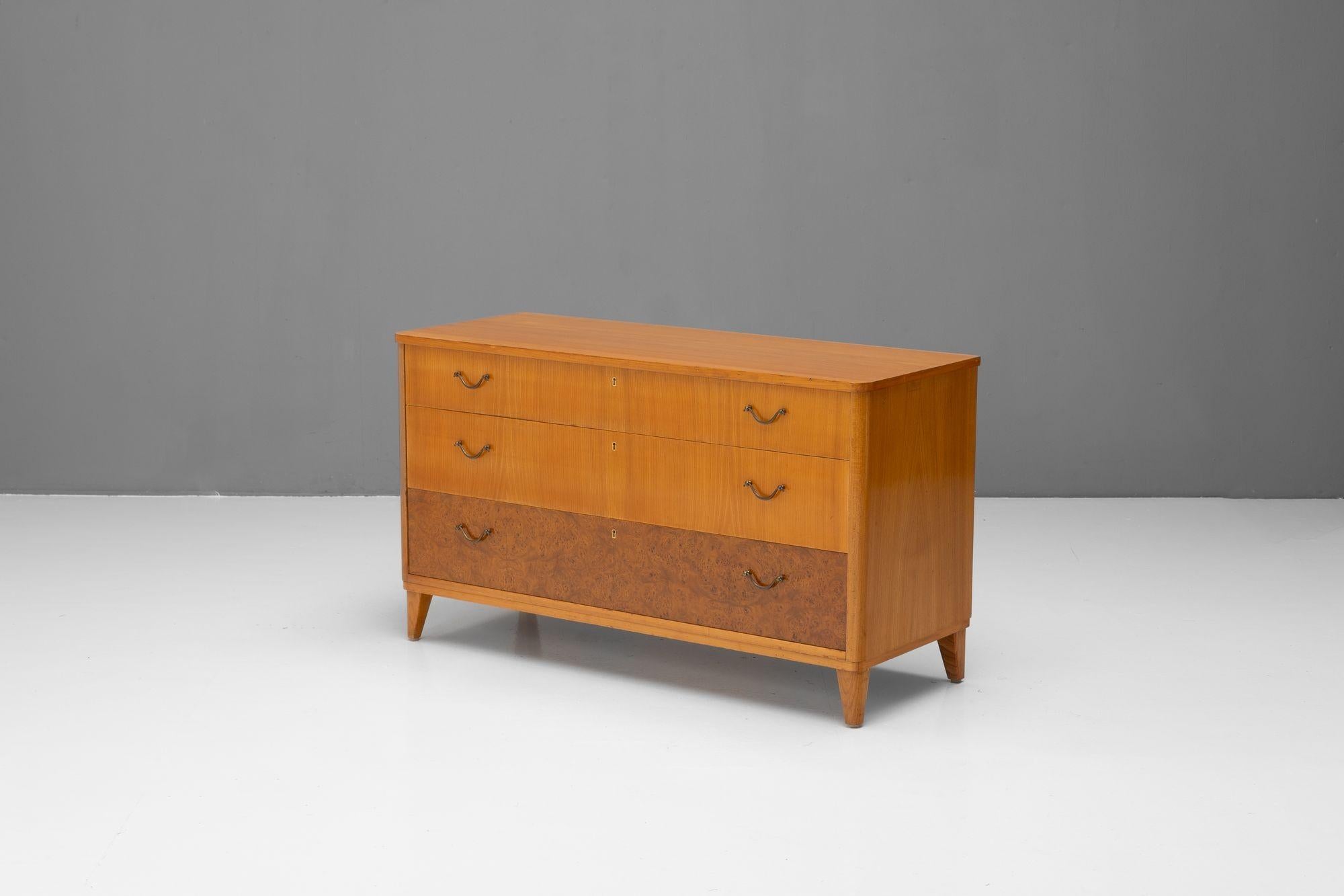 Cassettiera svedese a tre cassetti di metà secolo in olmo e radica. Maniglie originali. Rifinito. Svezia, circa 1950.

H. H. x L. 115 cm. x P. 44 cm.