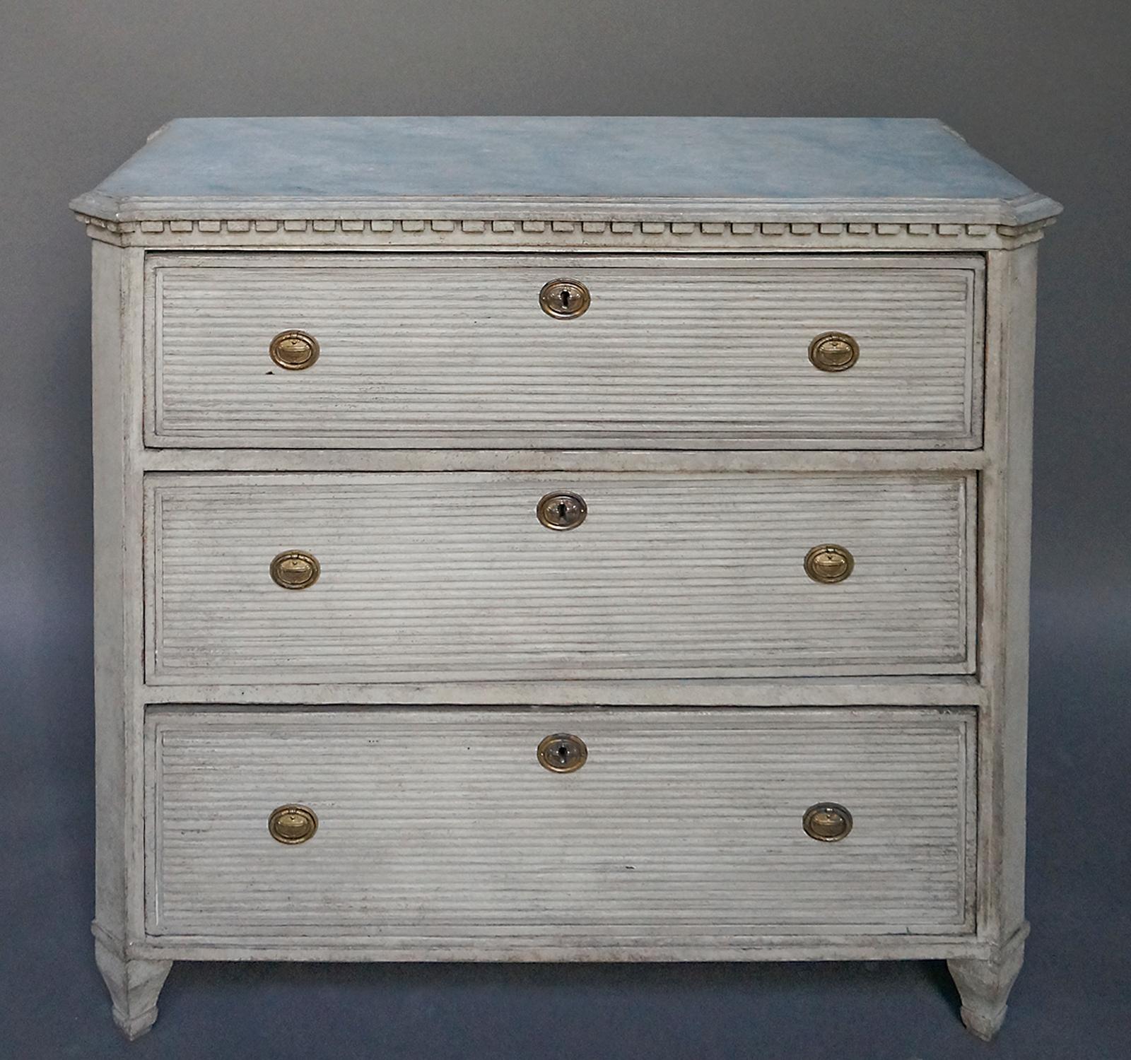 Gustavian style chest, Sweden, circa 1850, with three drawers with horizontal reeding. Canted corners and dentil molding under a marbleized and shaped top. Square, tapering feet.