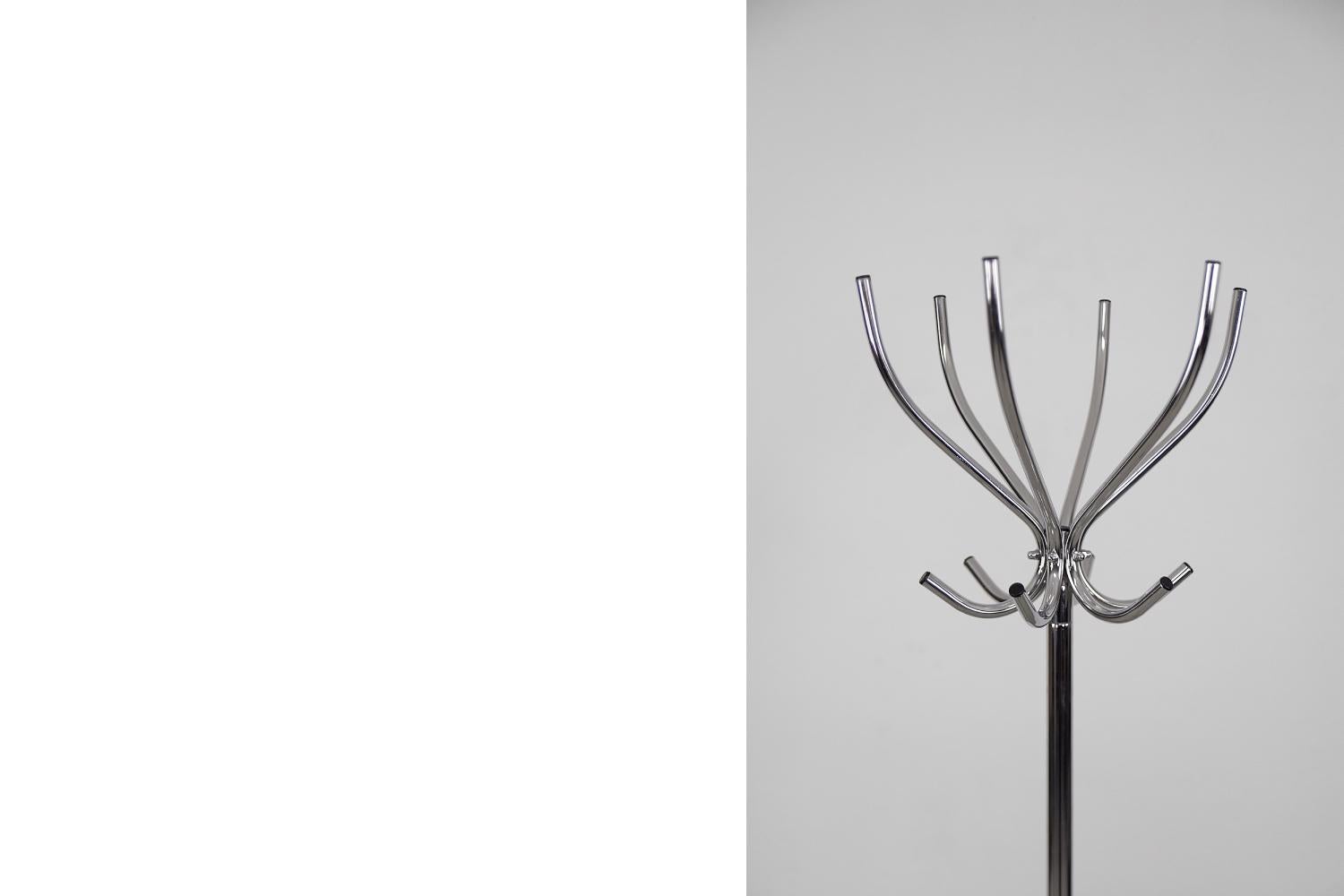 This chrome-plated floor rack was manufactured by the Swedish company Rörmekano and Skånes Fagerhult AB during the 1980s. It is Piccolo model. This piece is made of chrome steel. It has a crown with 12 hangers for clothes and is mounted on four