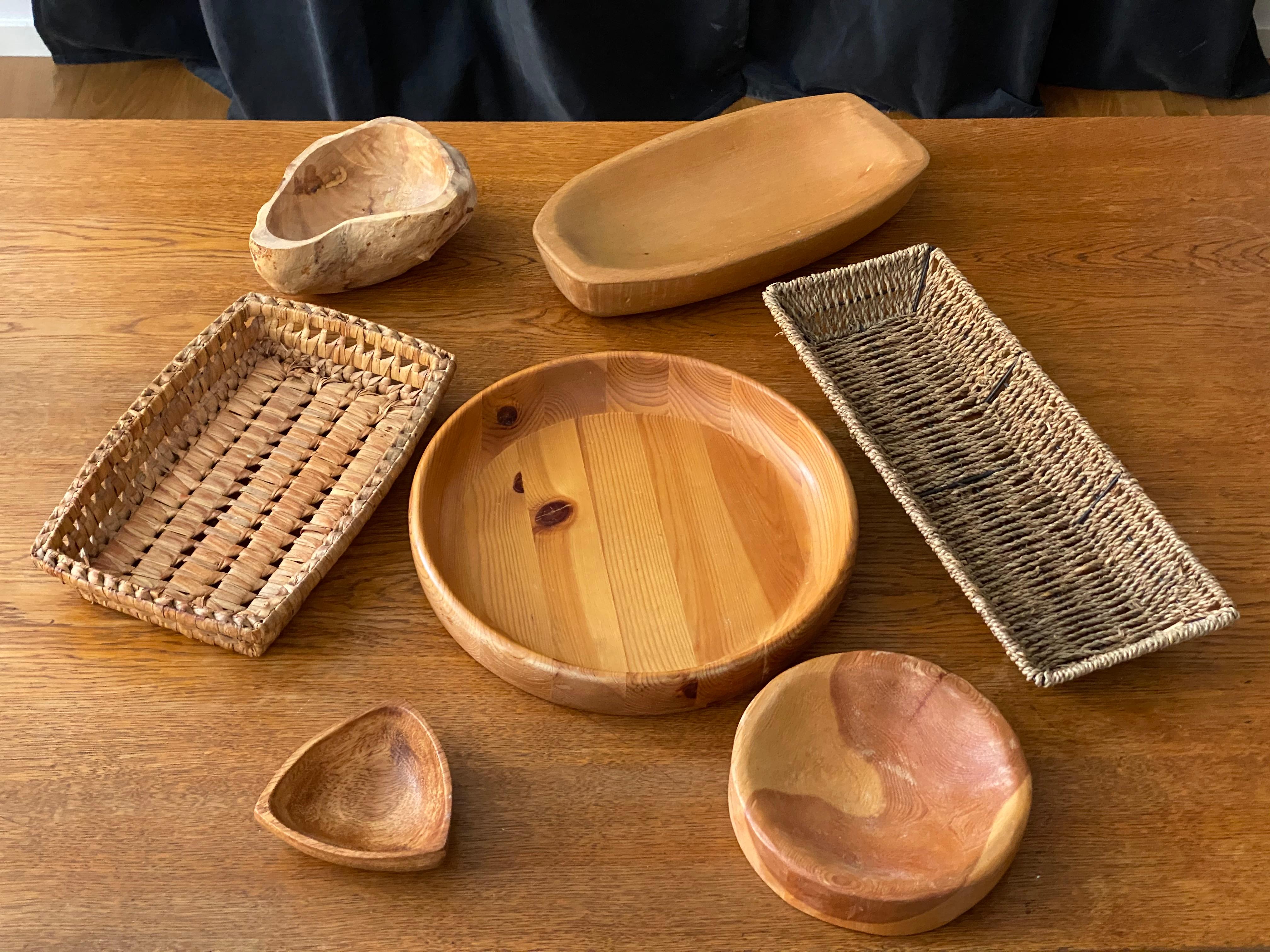 An assorted collection of seven Swedish decorative objects. Bowls, wooden dishes, trays. In teak, rope, beech, pine, rootwood, metal, circa 1950s-1970s

Dimensions in cm:

Large round pine plate / bowl H 5 cm, D 29.5
Small round pine plate /