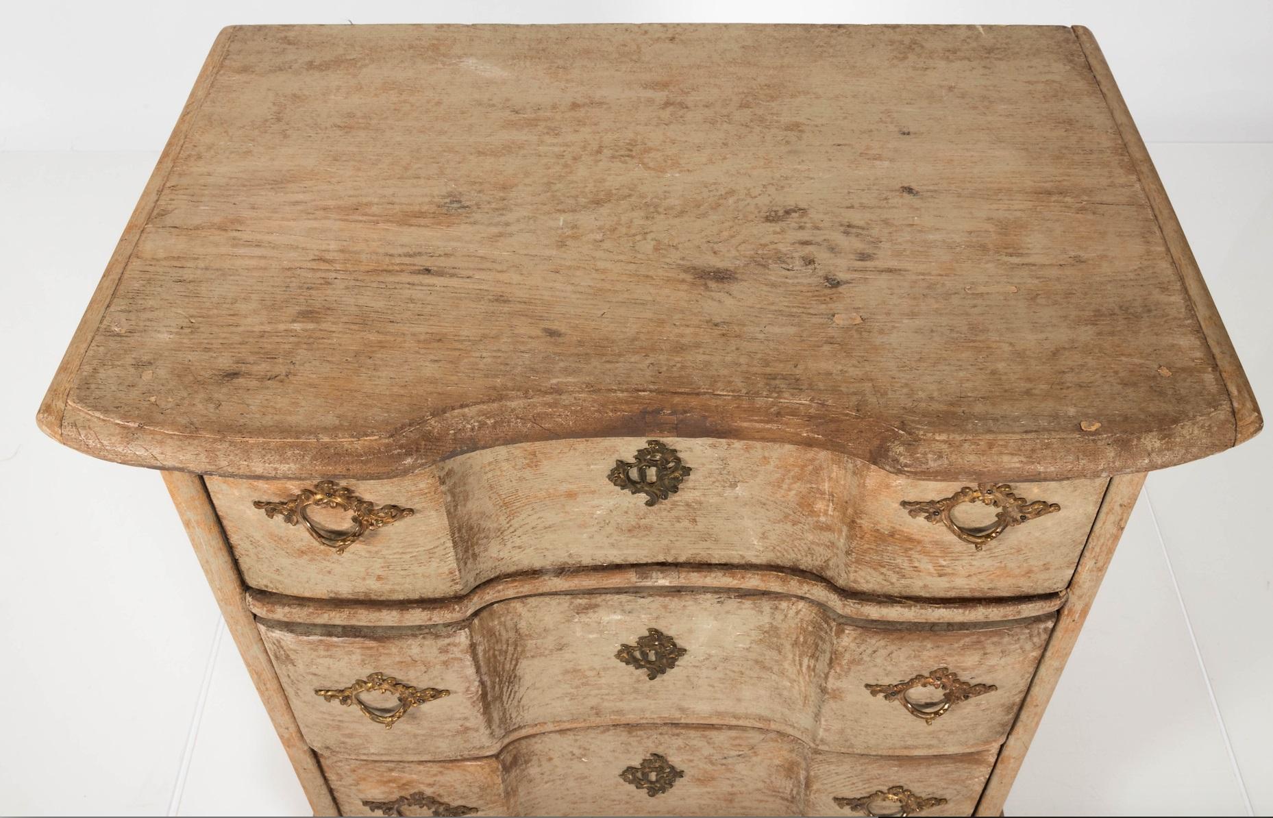Exceptional Gustavian three-drawer dresser with historic paint, made in Sweden circa 1750. This Swedish commode is painted a natural ecru hue that complements the warm pine wood showing underneath the surface. Honest age has given it the desirable