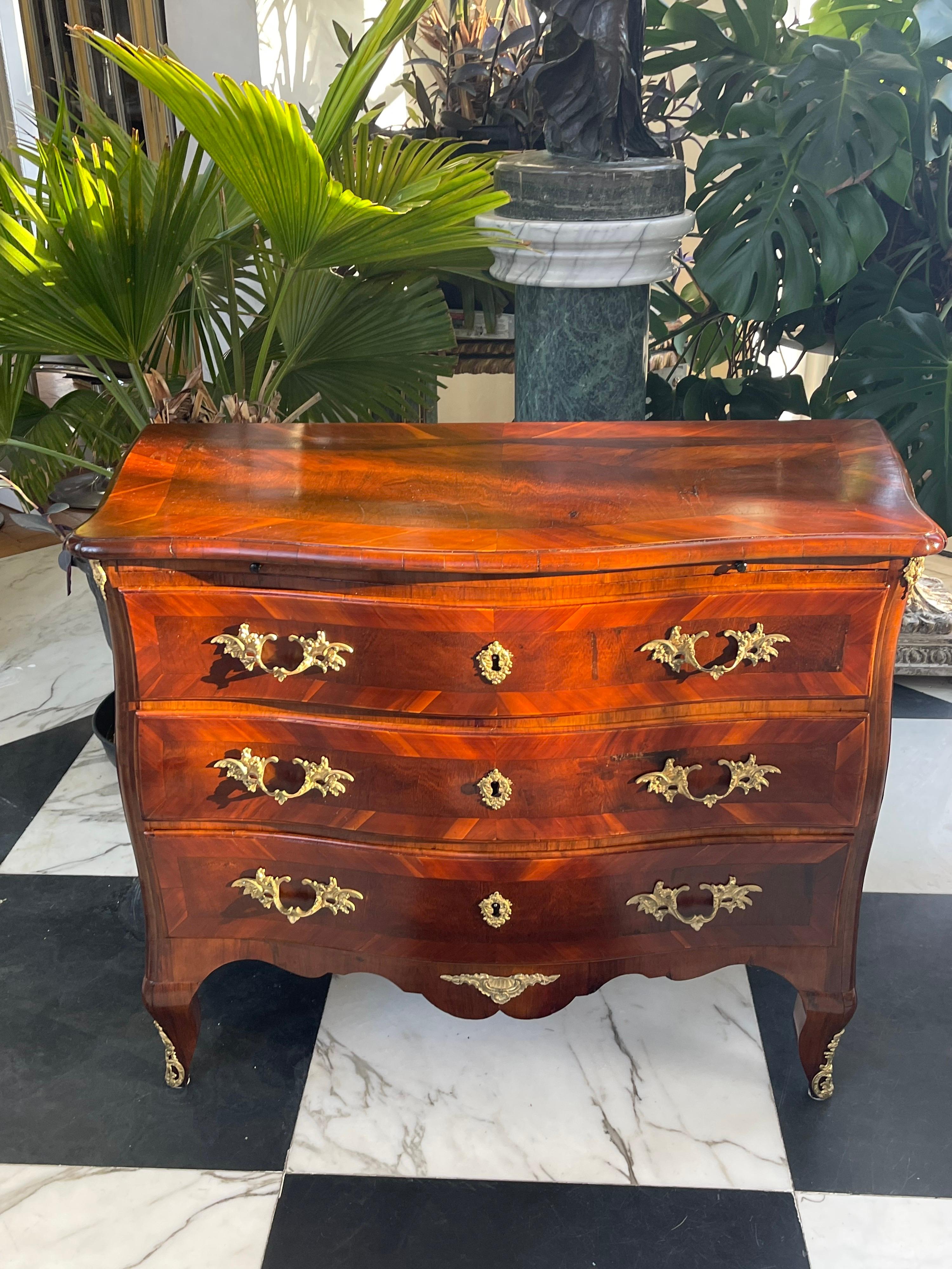 18th century Swedish serpentine front three drawer commode. Gustavian period, ca 1790. The body of chest is beautifully bookmatched veneered in Kingwood & Tulipwood, which has sun faded to the most desirable deep amber color hue. The secondary wood