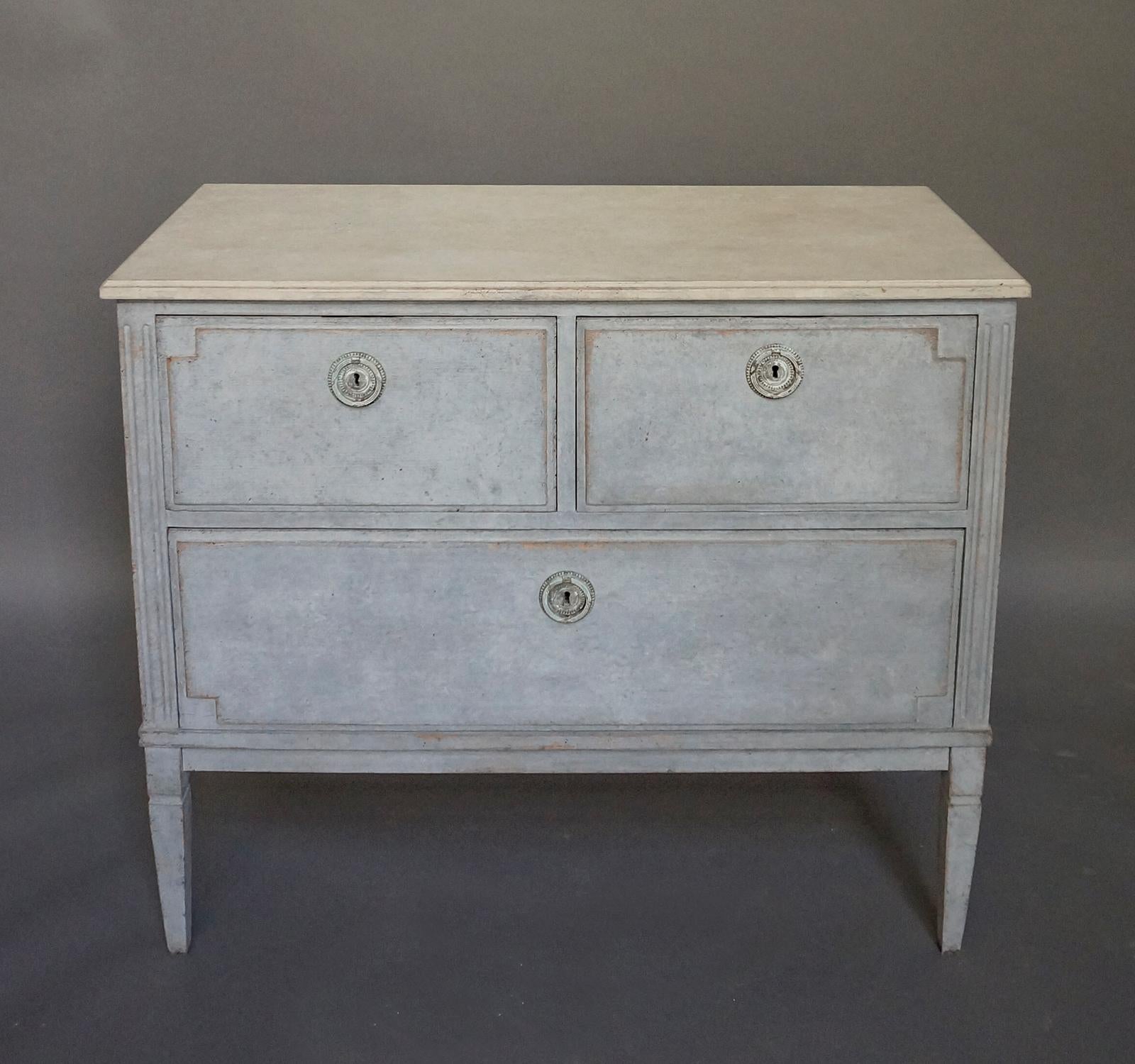 Two over one commode, Sweden, circa 1900, in the Gustavian style. Raised panels on the drawer fronts and fluted corner posts which extend into tapering square legs. A perfect size to use beside a bed or sofa.