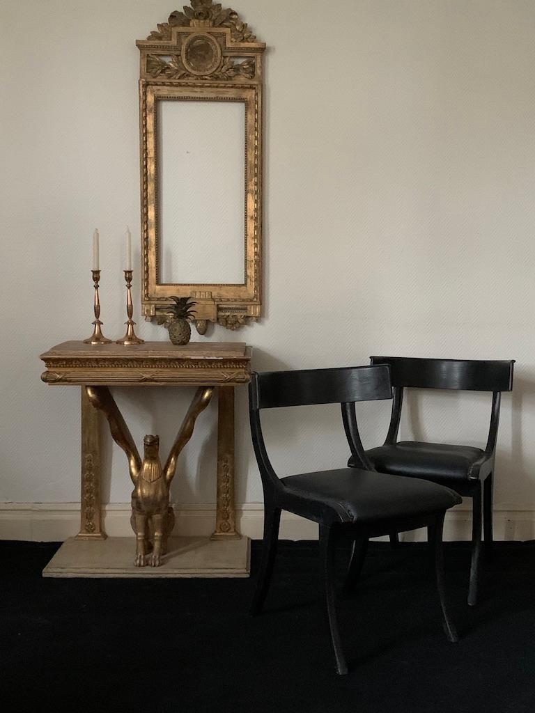 Empire Console table made in Sweden in early 19th Century. In original gilt with a wooden top made by skilled artisans in Stockholm. In the center sits an elegantly carved Griffon, supporting the top with its wings. The board is decorated with a
