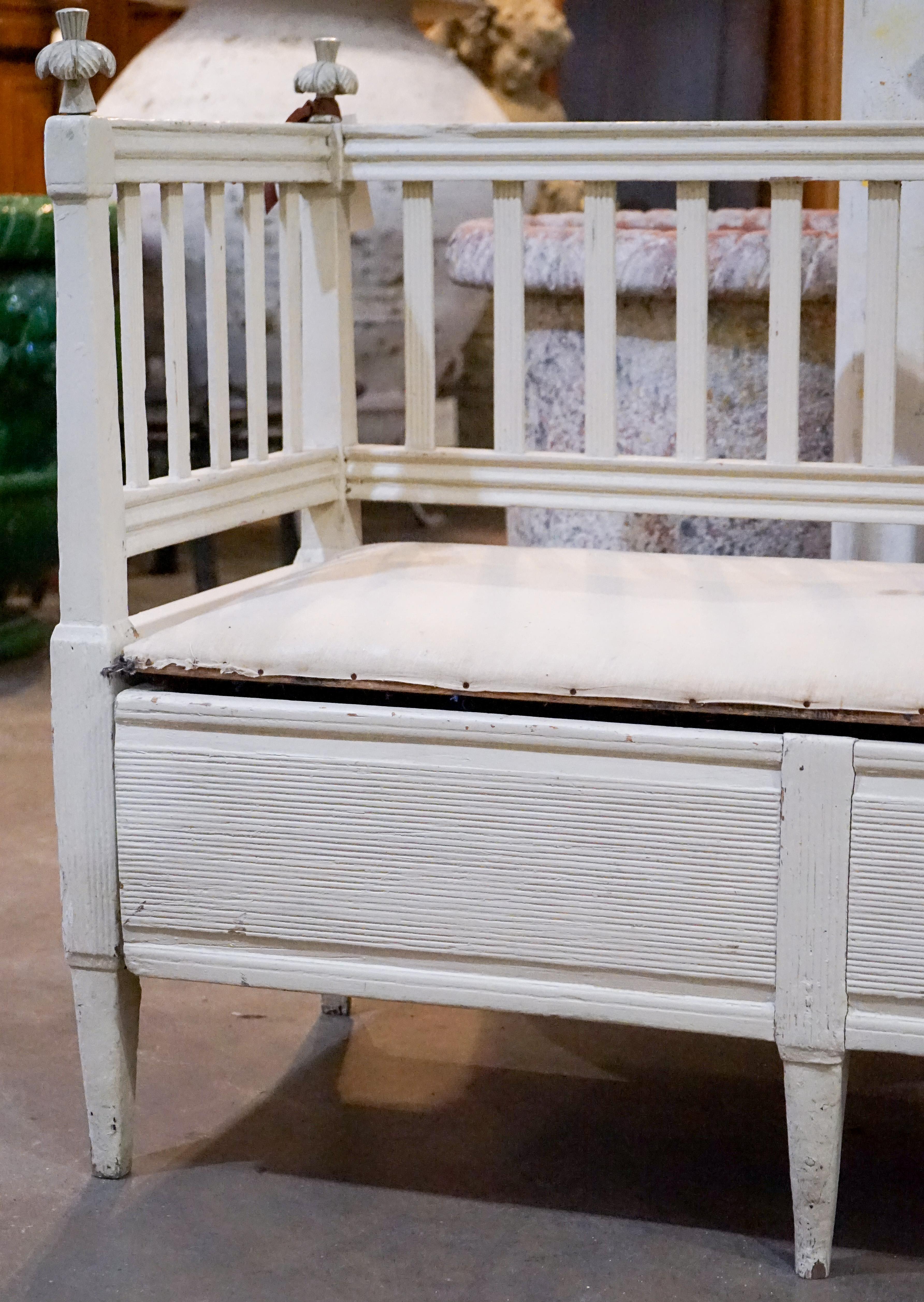 Swedish Gustavian bench coverts to double trundle bed. The original linen upholstered seat lifts to reveal an inner compartment that may be use as storage or, when the paneled front of the bench is pulled forward, space is made for a trundle bed.