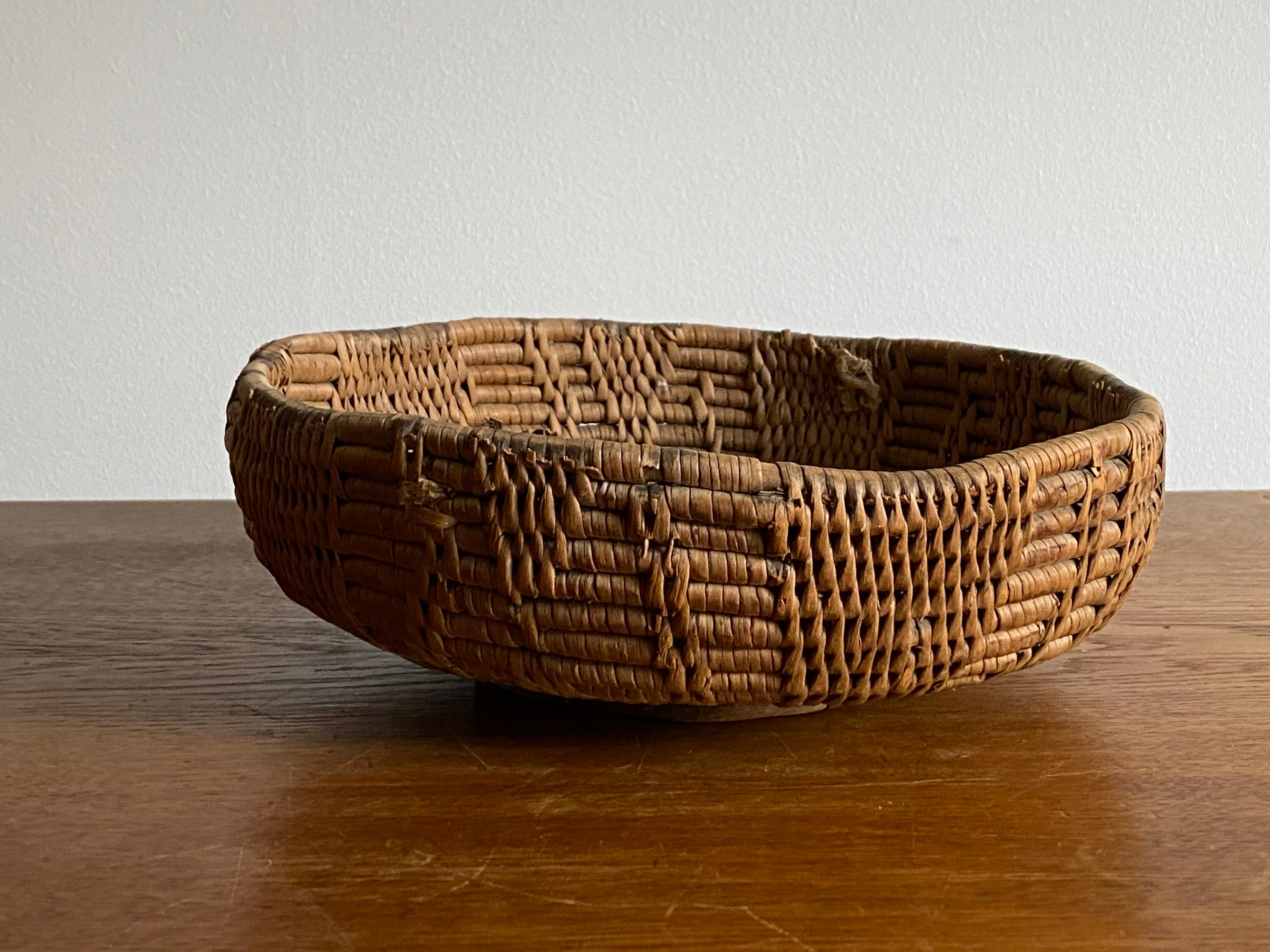 A handwoven basket or decorative bowl. Likely utilized as a form for cheese originally. Produced in Sweden, 19th century. In woven fir root.