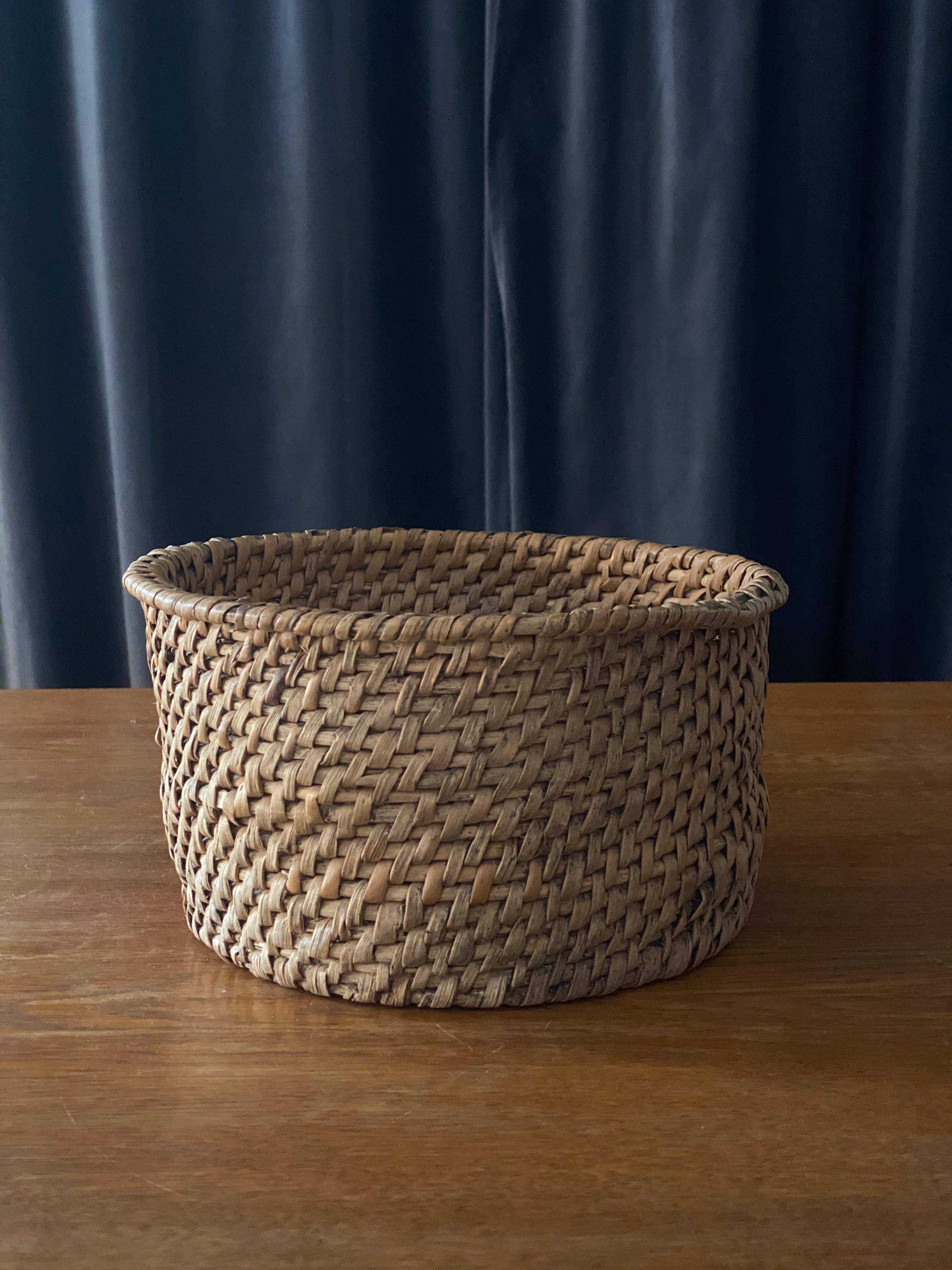 A handwoven basket or decorative bowl. Likely utilized as a form for cheese originally. Produced in Sweden, 19th century. In woven root.