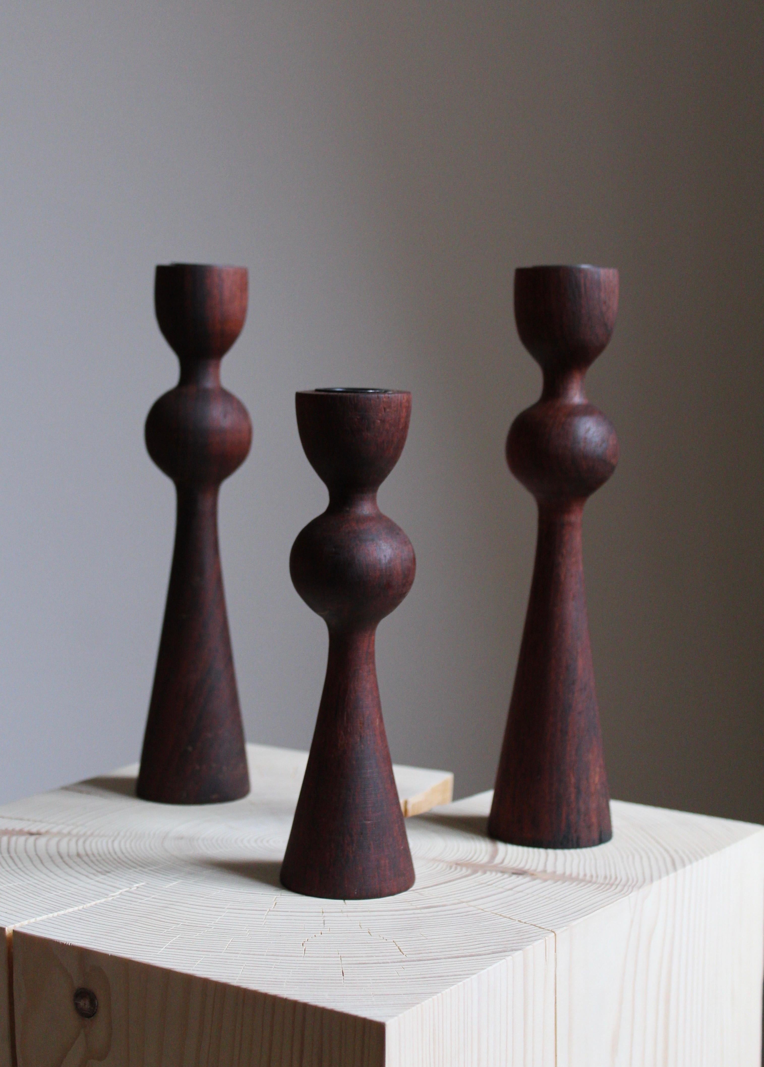 A set of 3 candlesticks / candleholders. In finely turned and stained solid teak. Produced in Sweden, circa 1970s.

          
