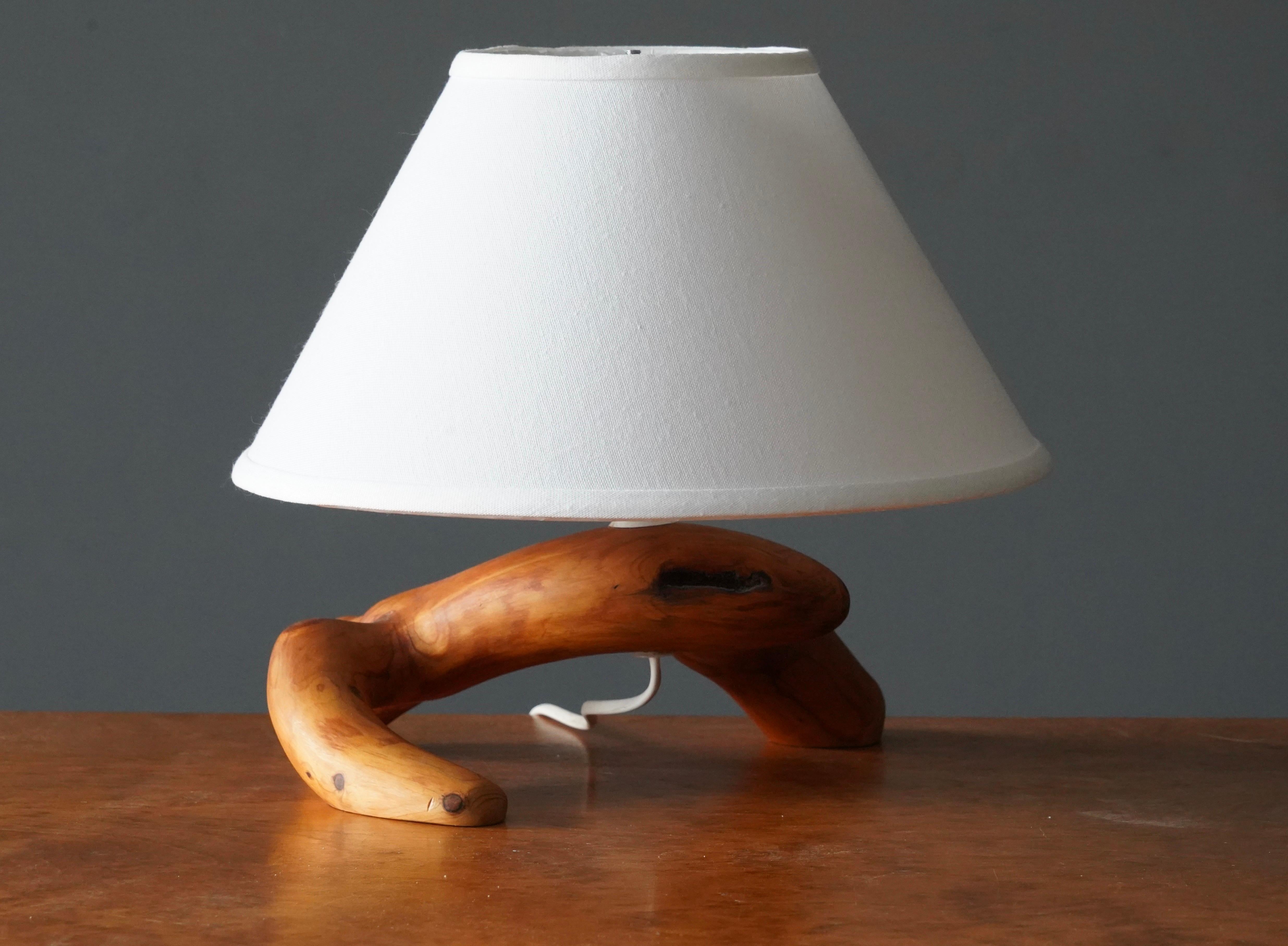 A handcrafted free form table lamp. In solid pine burl / driftwood. 

Dimensions listed are without lampshade. 
Dimensions with shade: height is 11 inches, width is 13.5 inches.
Dimensions of shade: top diameter is 5 inches, bottom diameter is