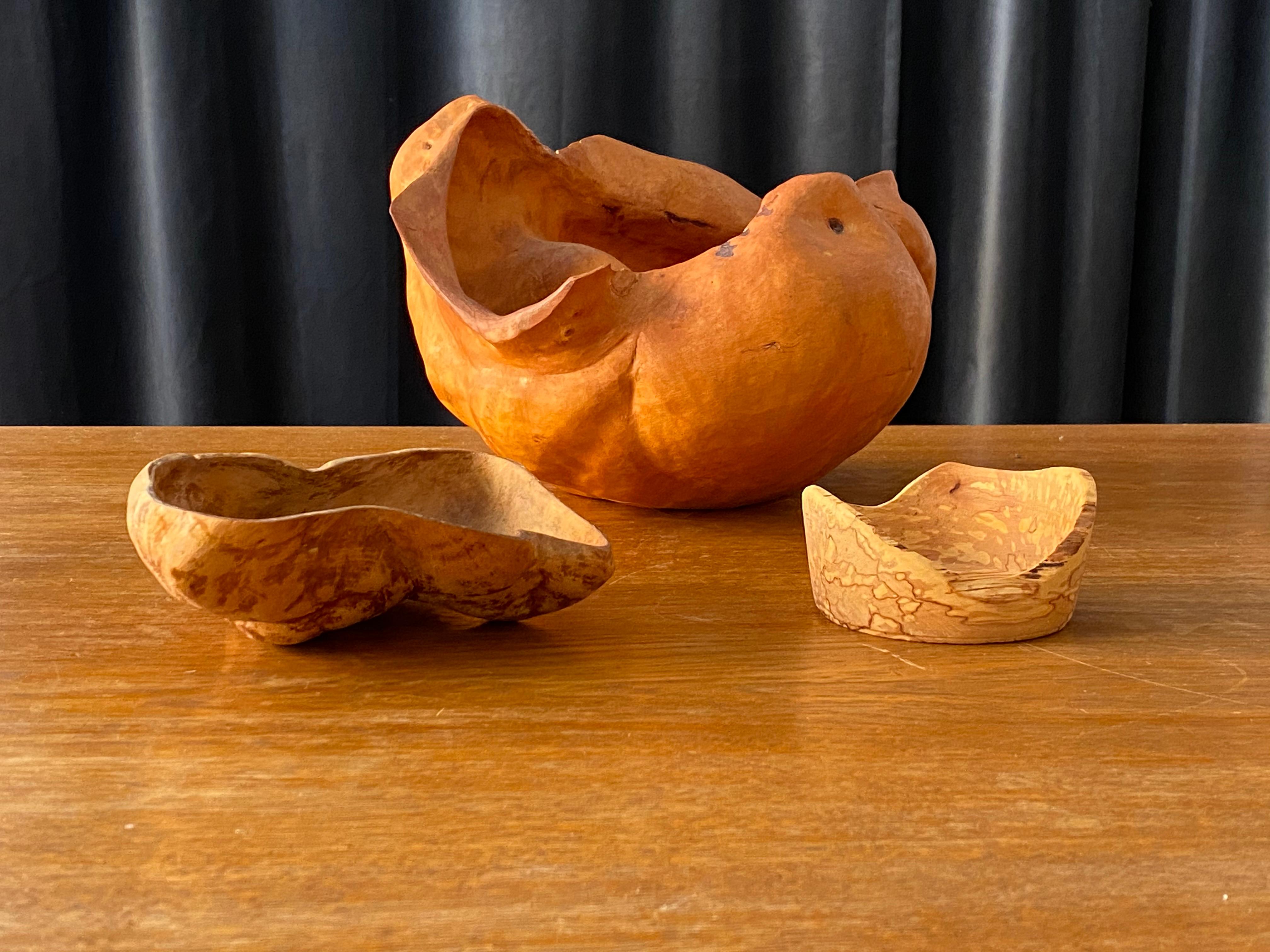 A set of 3 organically shaped root wood bowls. Assorted into a collection. Two bowls are signed. Largest is dated 1983.

Dimensions (in cm) largest to smallest:

W 29 x D 26, H 18.5

W 18, D 14, H 6.25

W 10, D 9.75, H 5.
   