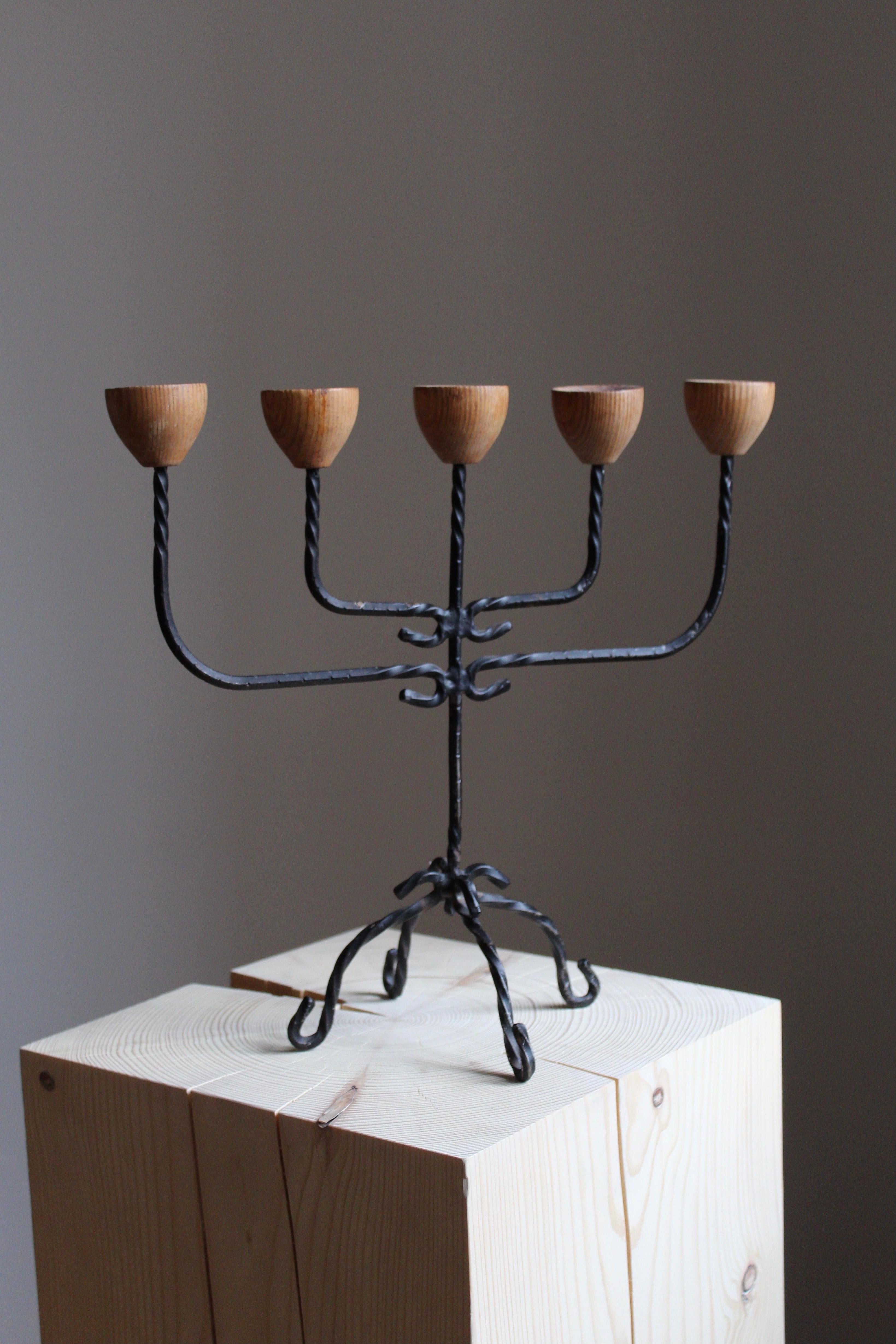A sculptural candelabra. Crafted in wrought iron and solid turned oak nossles. 

Other designers of the period include Diego Giacometti, Josef Frank, Piet Hein.