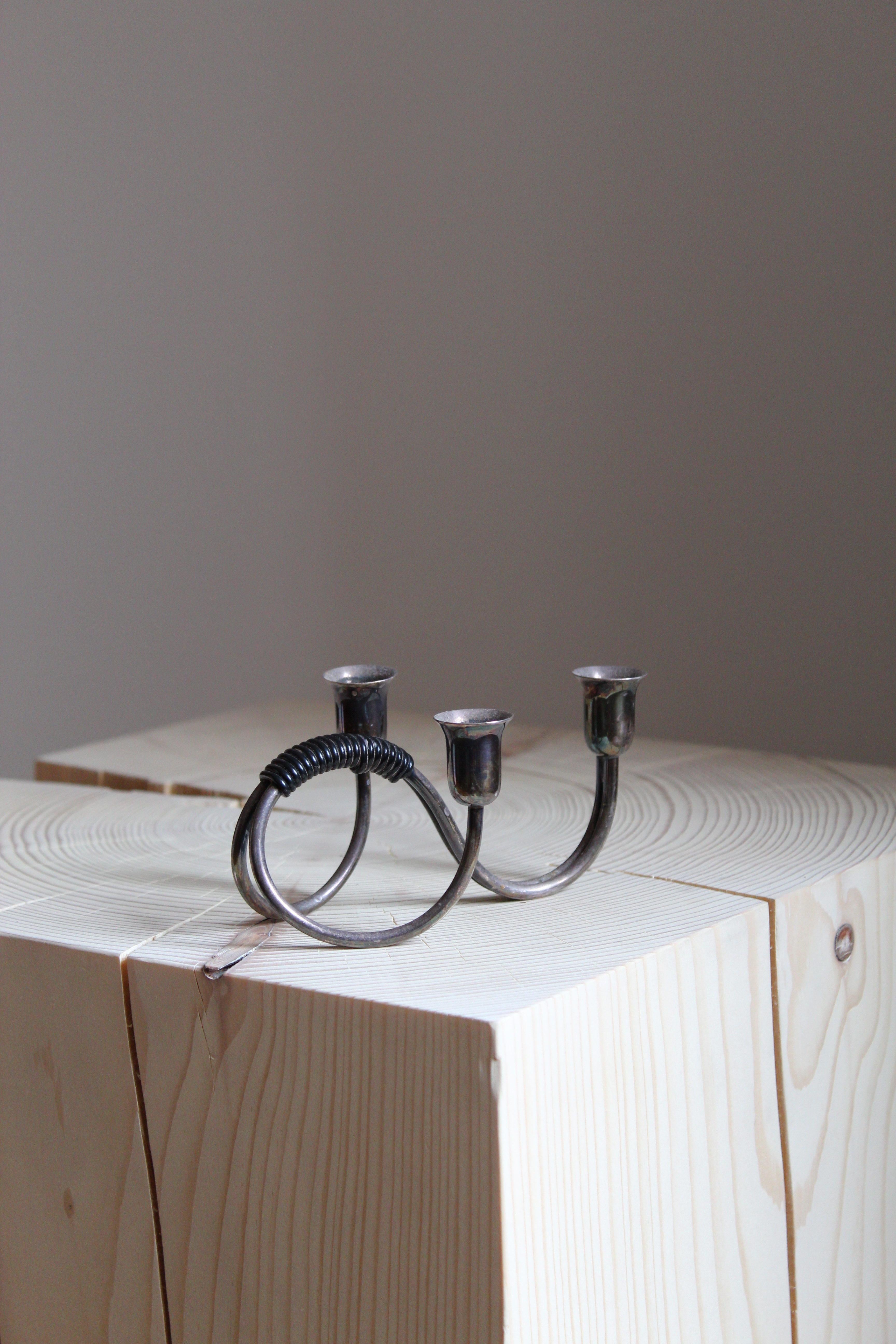 A set of very small organic candlesticks or candleholders. In steel and rubber.

 