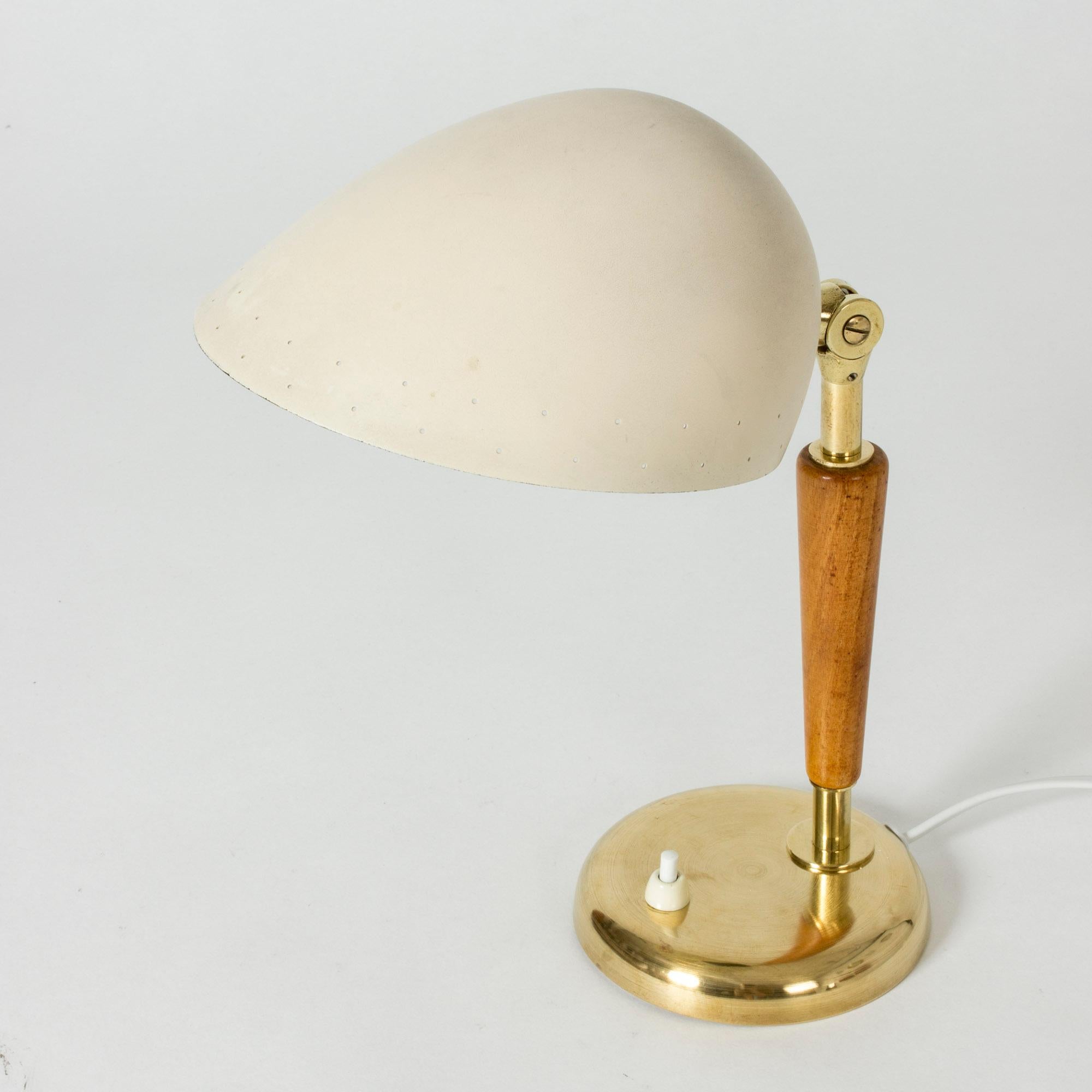 Neat, small table or desk lamp from Böhlmarks. Made from brass with a smooth wooden handle and an oval, streamlined metal shade. Cream colored lacquer.
      
