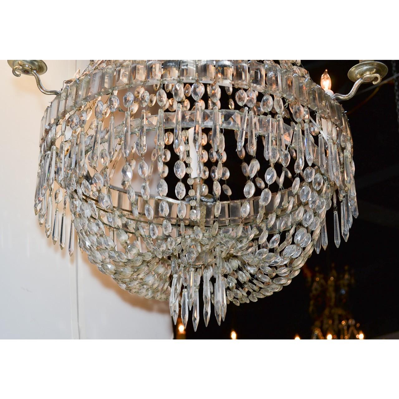 Understated antique Swedish crystal basket-form chandelier with strands of faceted bead prisms suspended from the crown adorned with baguette cut crystals and icicle prisms. The basket-shaped base surmounted by small scrolling arms and bobeche, and