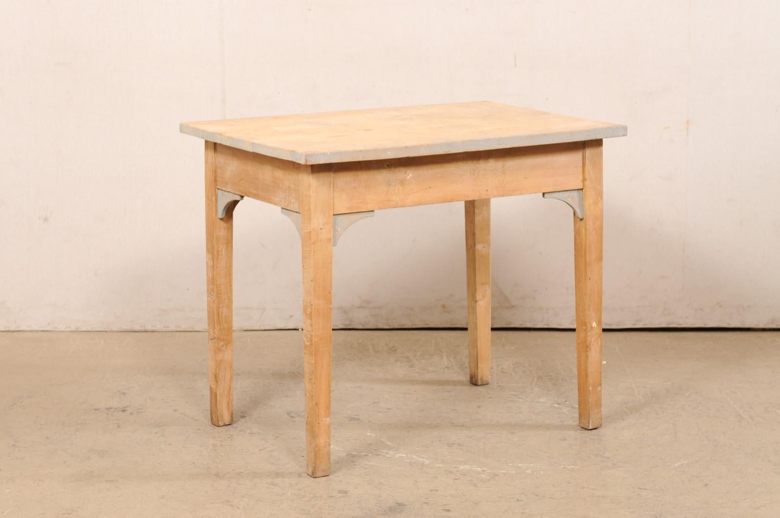 A Swedish occasional table of curly birch wood from the early 20th century. This antique table from Sweden is rectangular in shape and has been designed in clean/linear lines. The top overhangs the apron below, which is plain but with curved