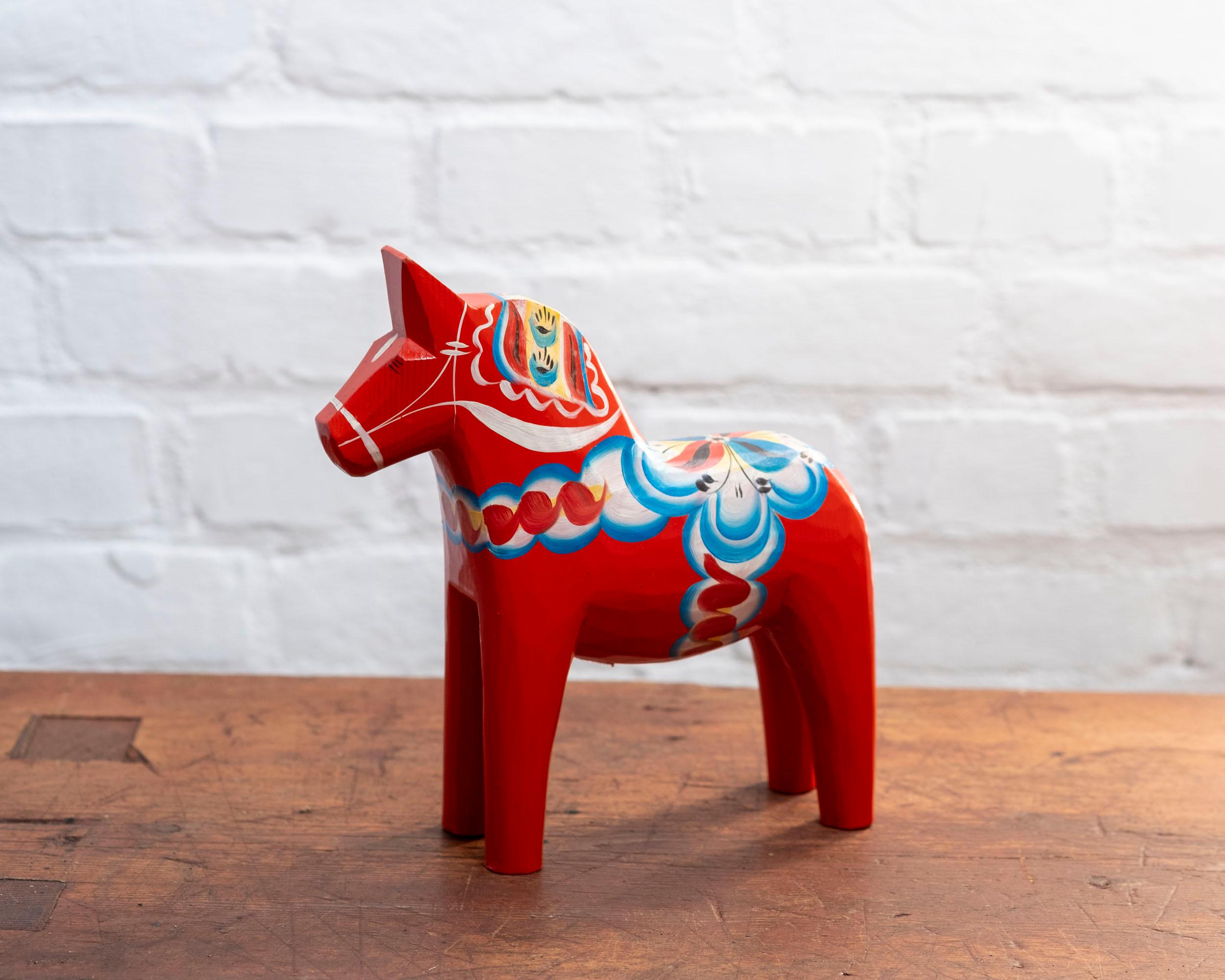 Vintage Swedish Dala Horse by Nils Olsson for Grannas A. Olssons Hemslöjd, circa 1990s. The horse is in good vintage condition and is hand-painted red with decorative accents.
This Dala Horse is the tallest model that's made from one solid piece of