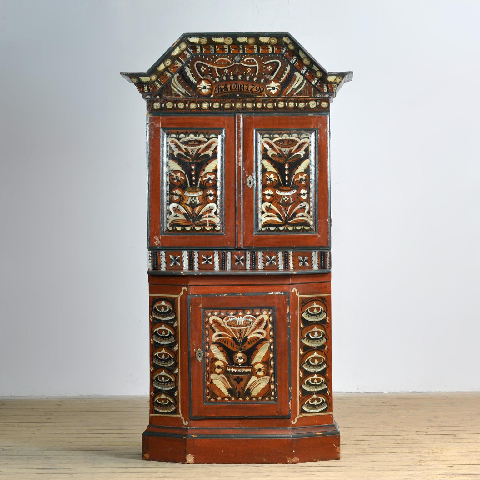 A magnificent example of Swedish craftsmanship and folk art from the Dalarna region. This cupboard is beautifully painted in earth tones with light and dark blue accents on almost every surface. Special features include the large stepped cornice