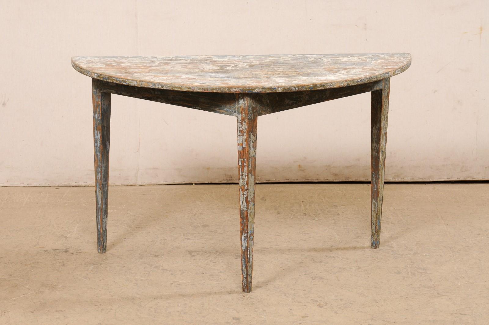 A single Swedish wooden demi-lune console table from the 19th century. This antique table from Sweden features a semi-circular, or half moon top, over a triangular shaped apron. The skirt is clean and plain, and the piece is raised upon three