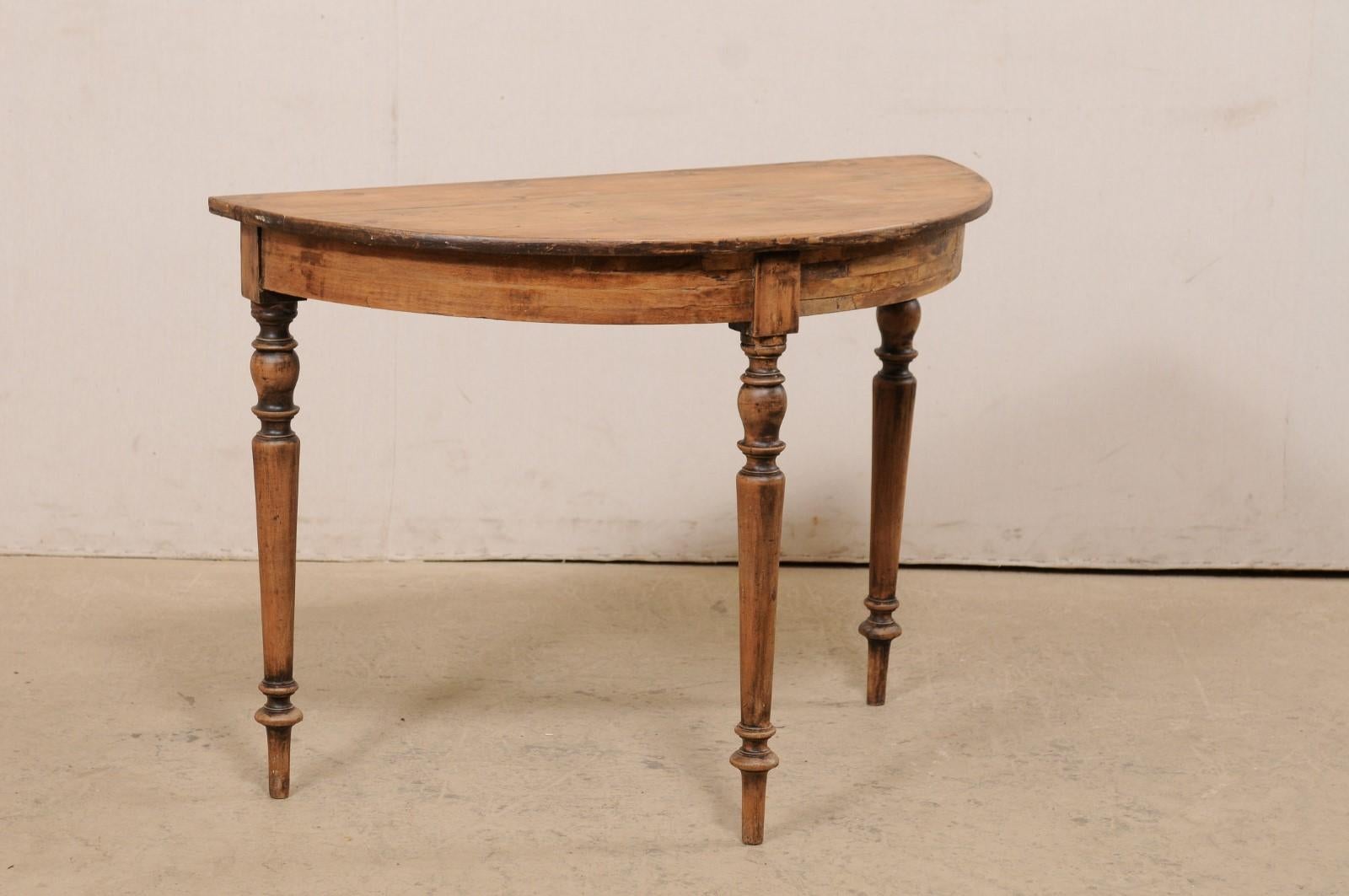 A Swedish carved-wood single demi-lune table from the 19th century. This antique demi-lune table from Sweden, circa 1880's, features a semi-circular top over a plain, rounded apron. This table is raised upon three nicely carved/turned rounded legs,