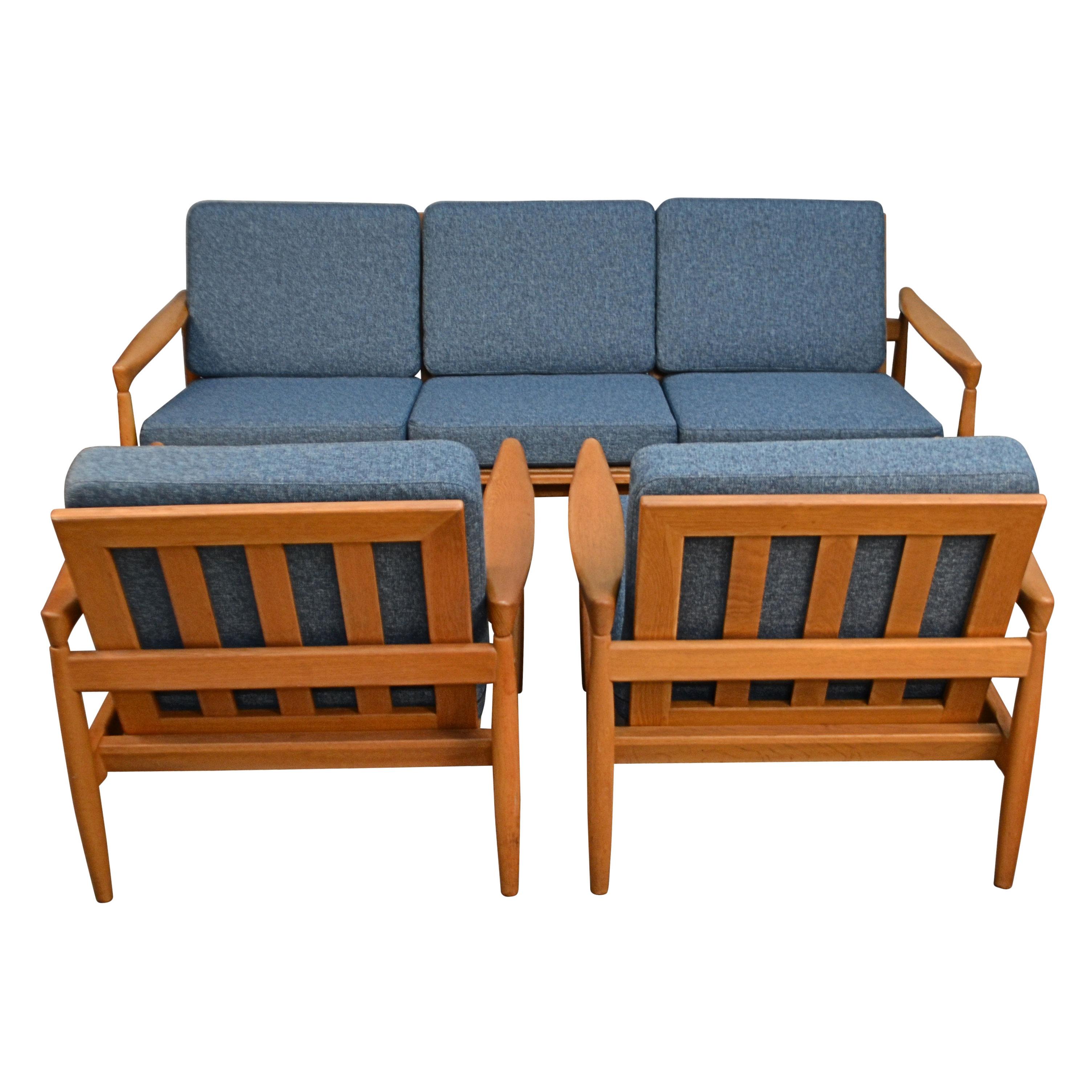 Vintage oak seating group model Kolding consisting out of a three-seater sofa and two lounge chairs. Designed and manufactured by Danish designer Erik Wørts. The organic clear lines and the gorgeous oak wood make for a typical vintage Danish design.