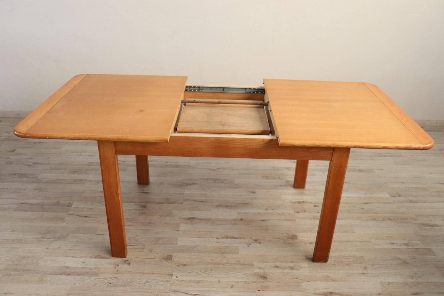 Swedish design solid oak wood dining room extended table, 1970s. Dimensions extended table cm 185 / inches 72.83. 
In good vintage conditions. This table is perfect for a modern home, its opening is practical and the extension disappears inside the