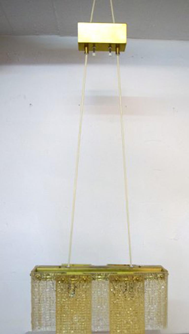 Design/One pour Elidus. Plafonnier en verre d'art avec fixation en laiton, années 1960.
En très bon état.
Dimensions : 40 cm x 21 cm. Longueur totale 93 cm.