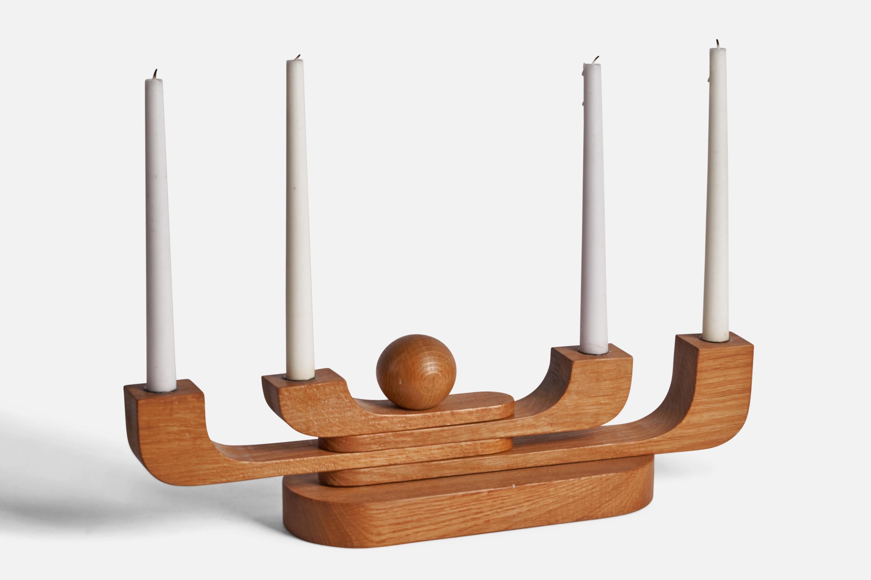 An adjustable oak candelabra, designed and produced in Sweden, c. 1950s.

Holds 0.76” diameter candles.