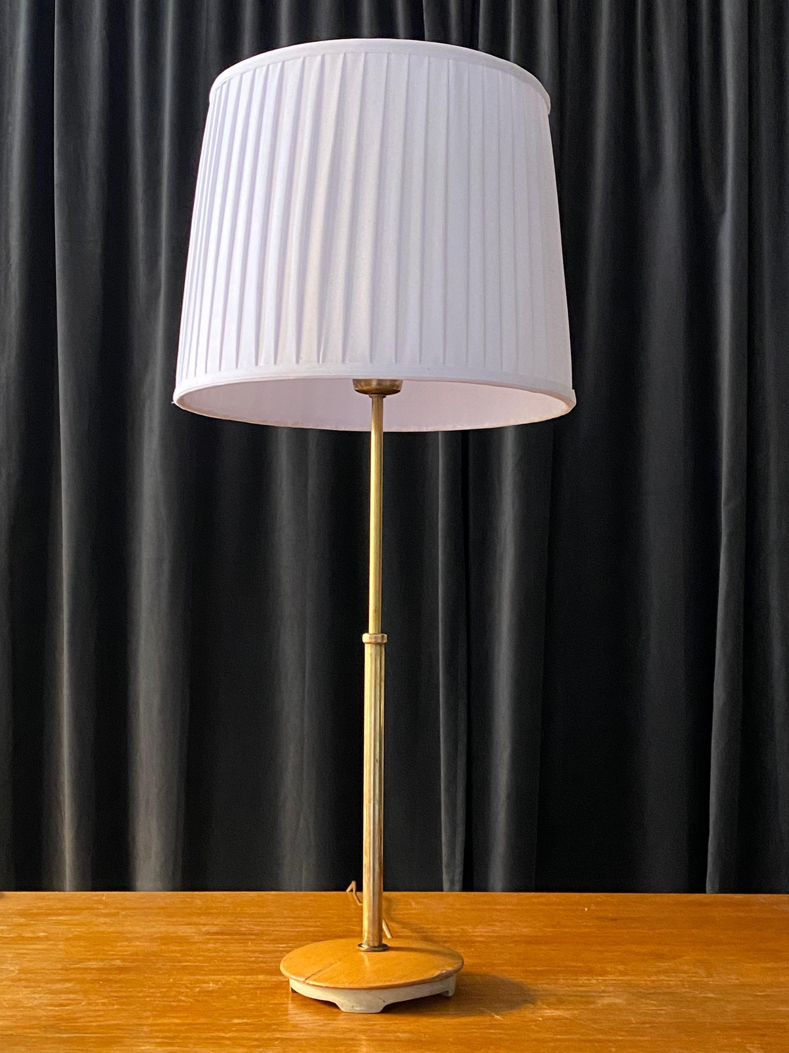 A functionalist table lamp, Designed by Bertil Brisborg produced by Nordiska Kompaniet in Sweden, 1940s. Adjustable, with current oversized shade, the height can be set from 55 cm / 21.65 in to 75 cm / 29.5 in.

In brass, base in grey painted iron