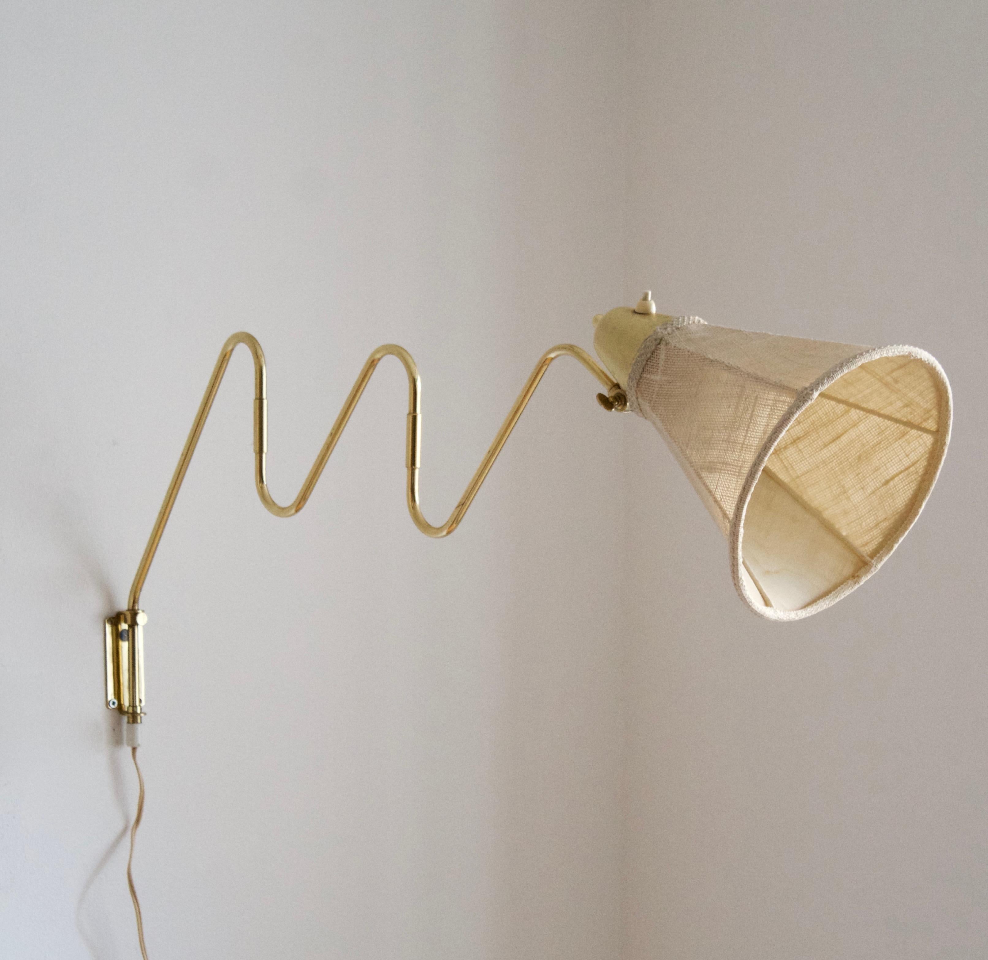 A functionalist wall light / task light, designed and produced in Sweden, 1940s. Features brass. Original fabric lampshade.

Stated dimensions with lampshade attached as is illustrated in the primary image.