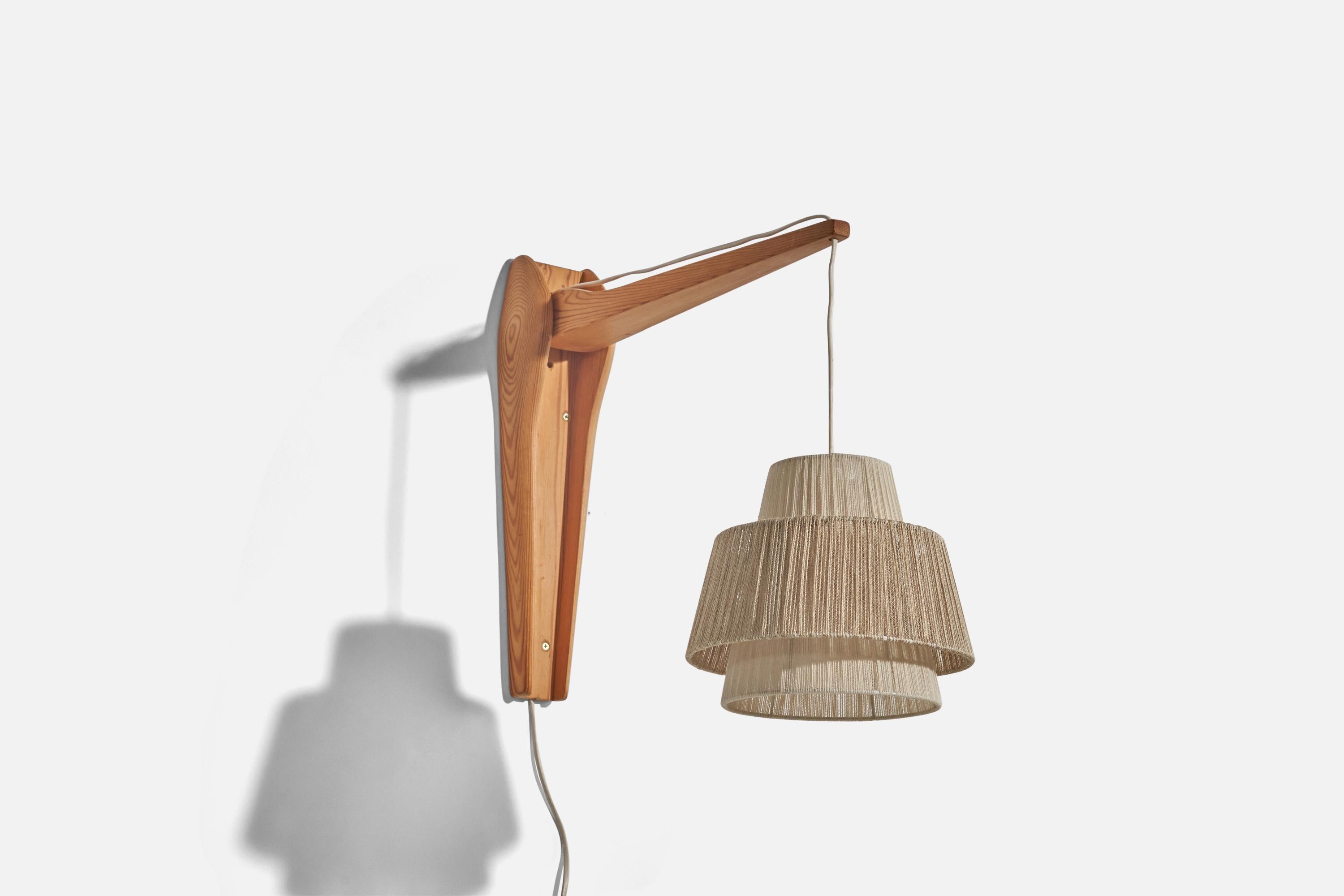 A pine and string, adjustable wall light designed and produced in Sweden, c. 1960s. 

Variable dimensions, measured as illustrated in the first image.
Sold with Lampshade(s). 
Stated dimensions refer to the Sconce with the Shade(s).
Dimensions of